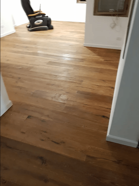 A vacuum cleaner is sitting on a wooden floor in a room.