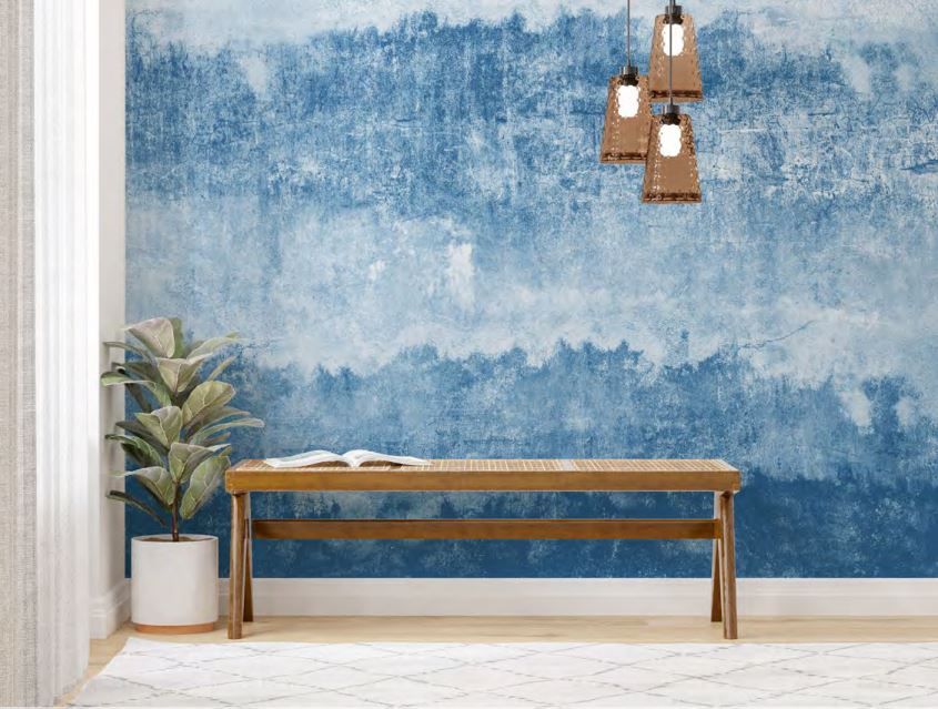 There is a bench in front of a blue wall.