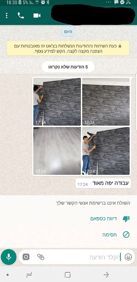 A man is painting a wall on a phone.