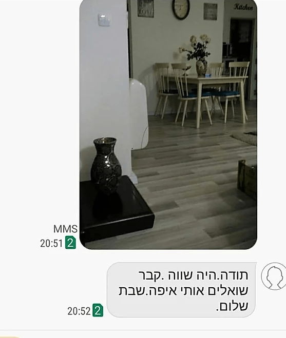 A picture of a living room with a table and chairs and a vase on a table