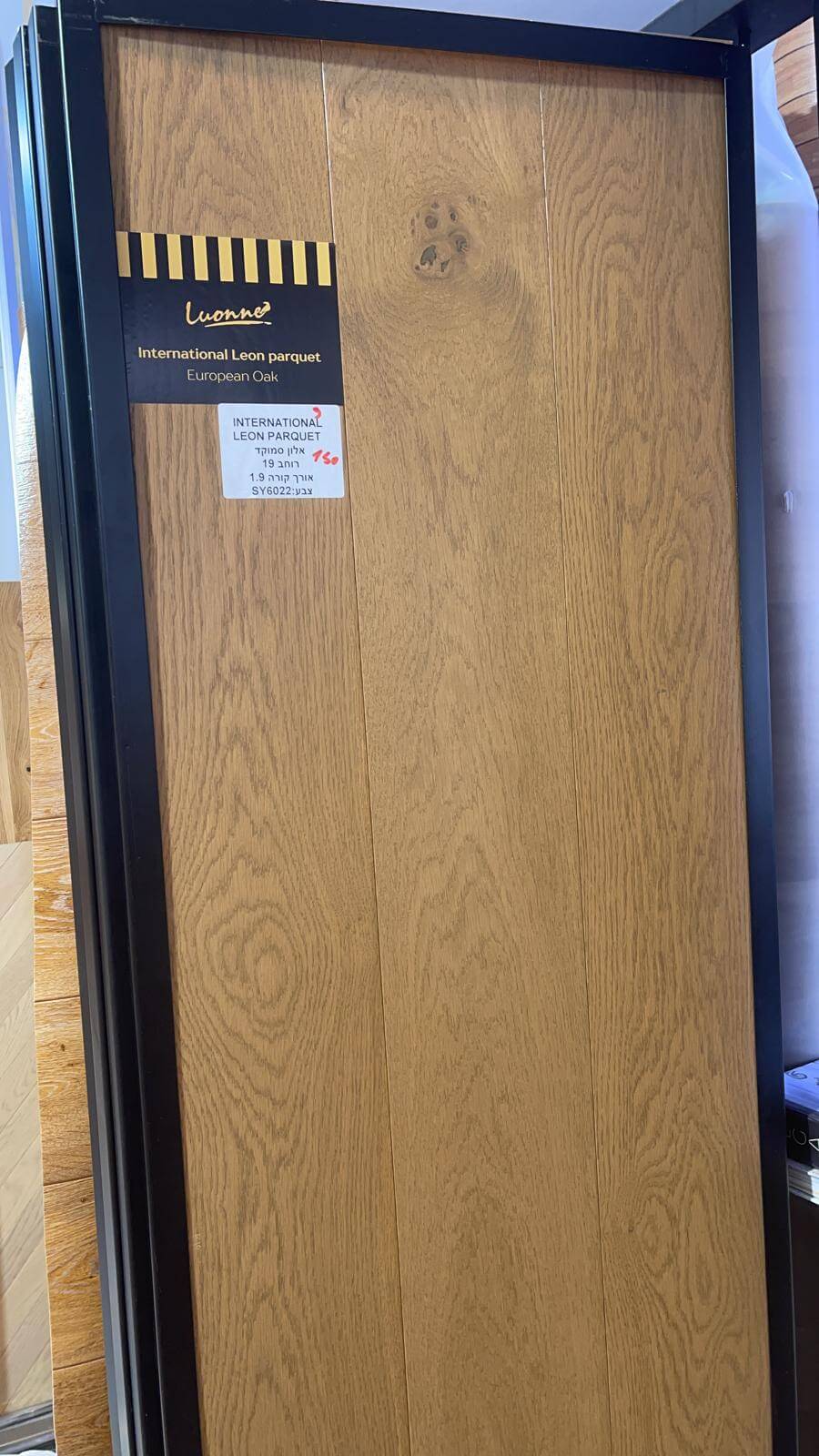 A wooden door with a black frame is sitting on a shelf.