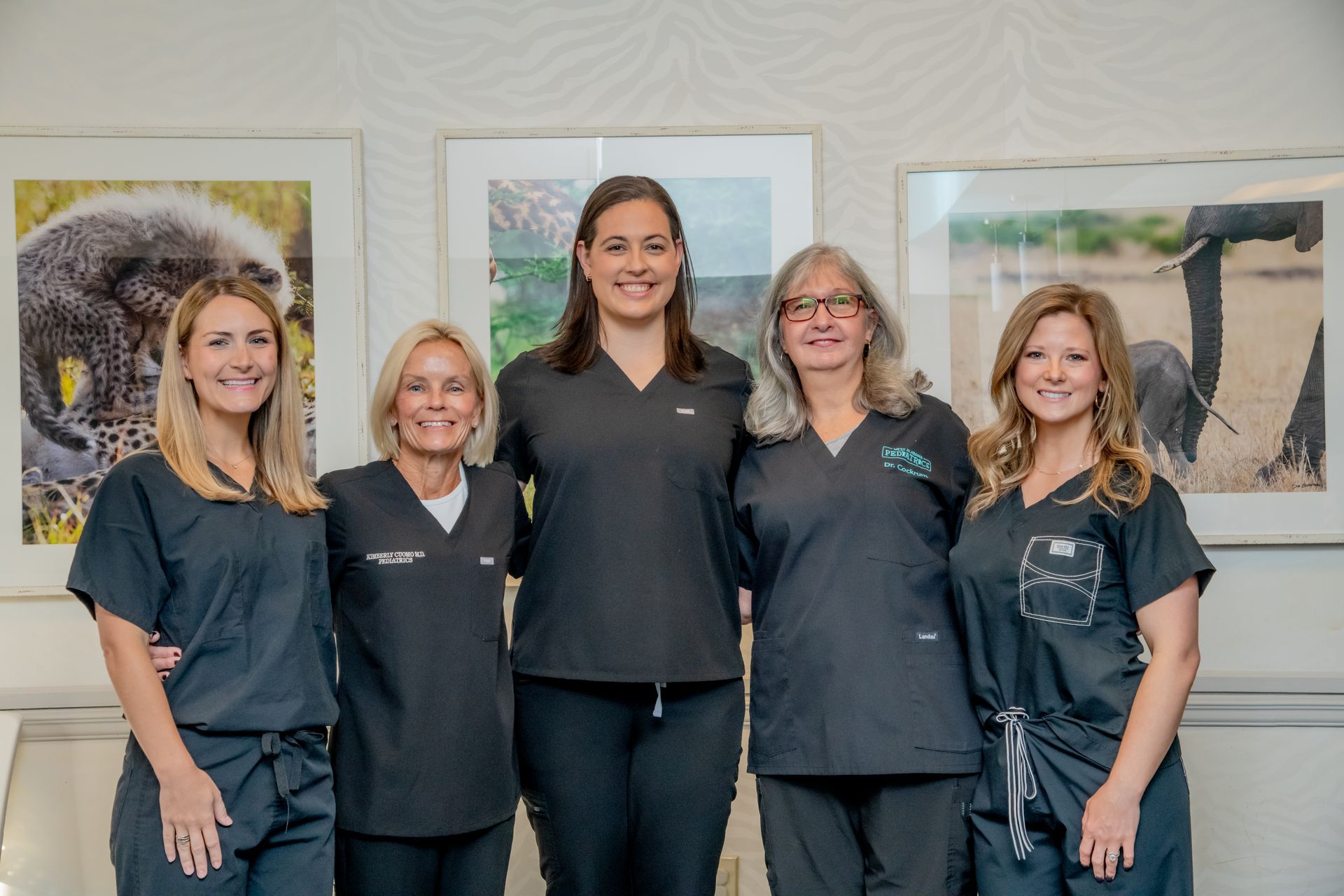 A group of women in scrubs are posing for a picture.