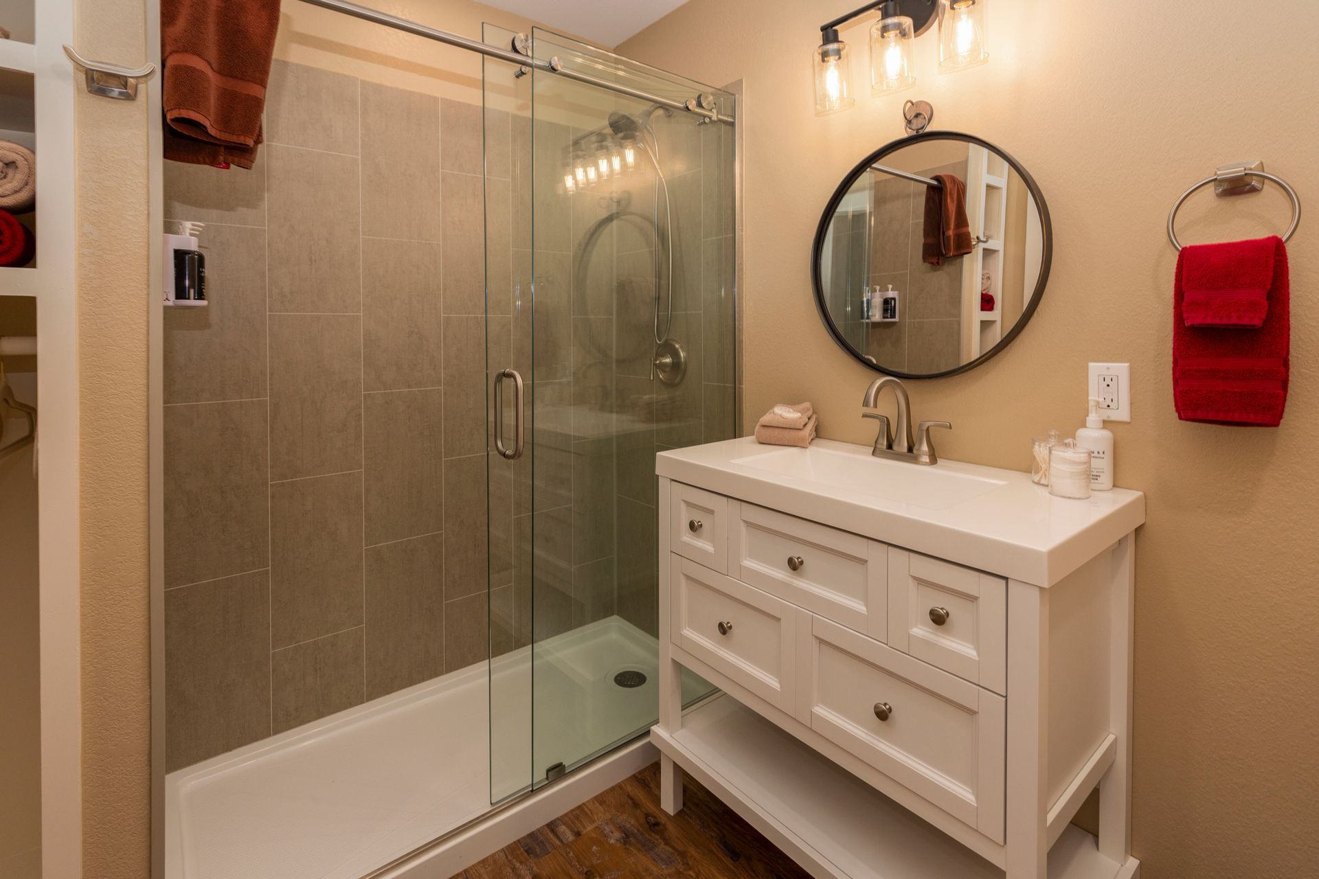 A bathroom with a sink , shower , and mirror.