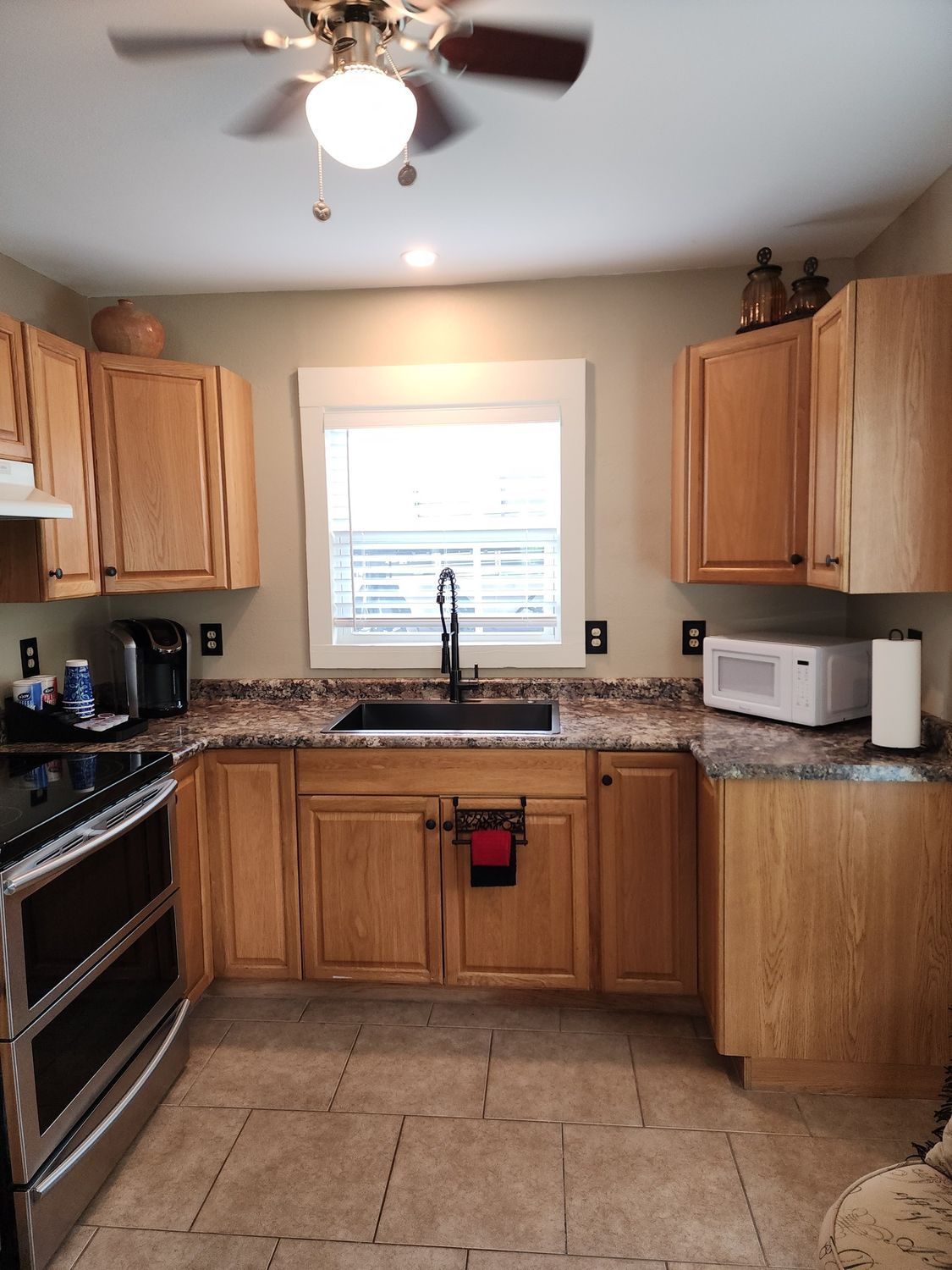 A kitchen with wooden cabinets and a ceiling fan