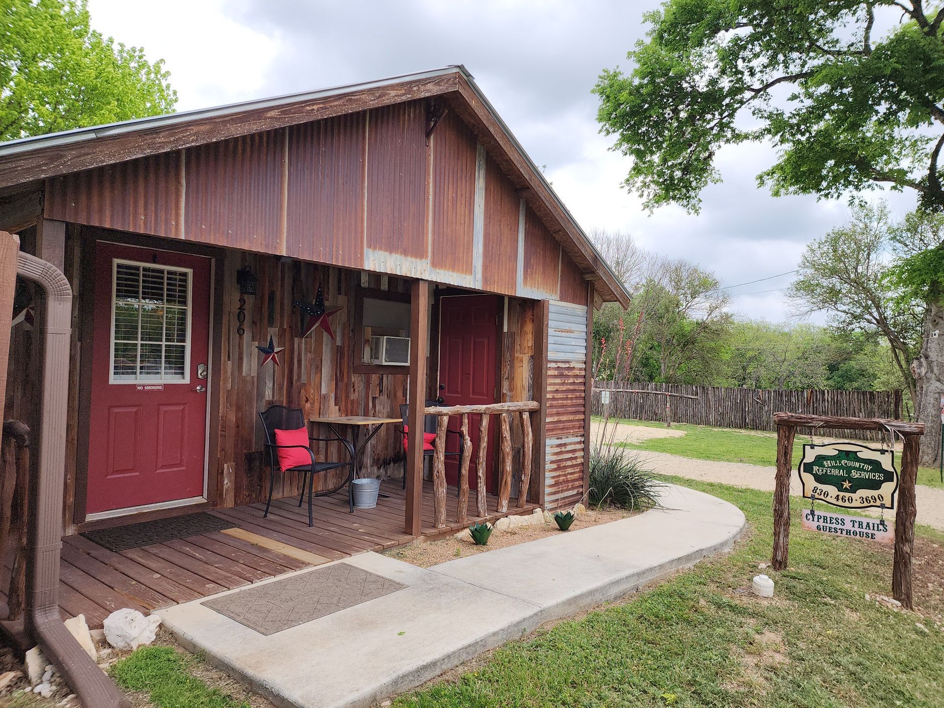 A small wooden cabin with a red door and porch.