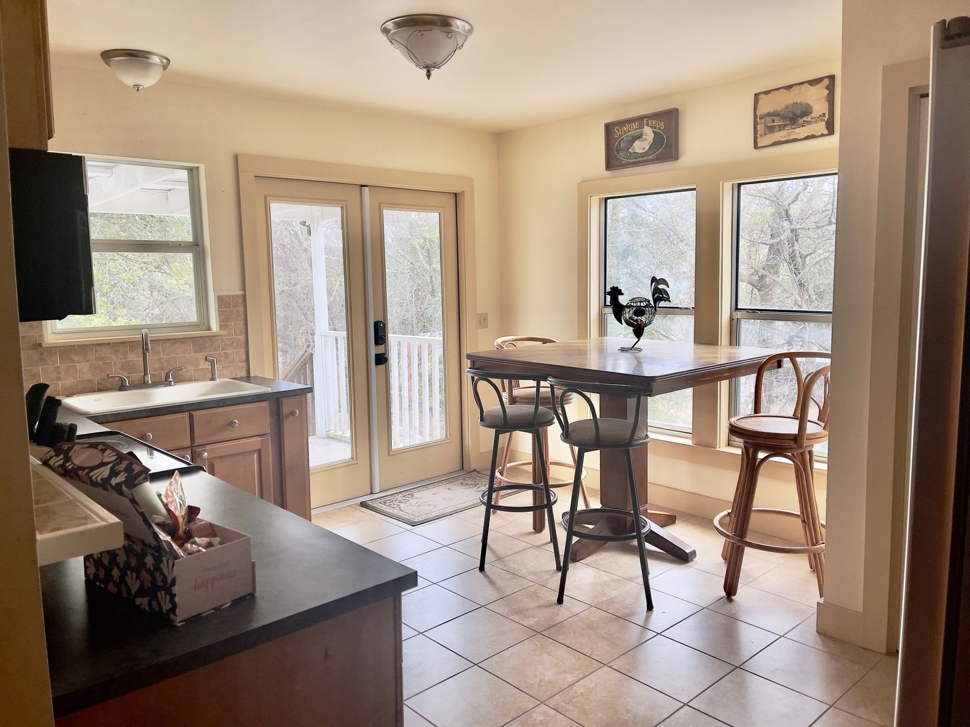 A kitchen with a table and chairs and a rooster on the counter