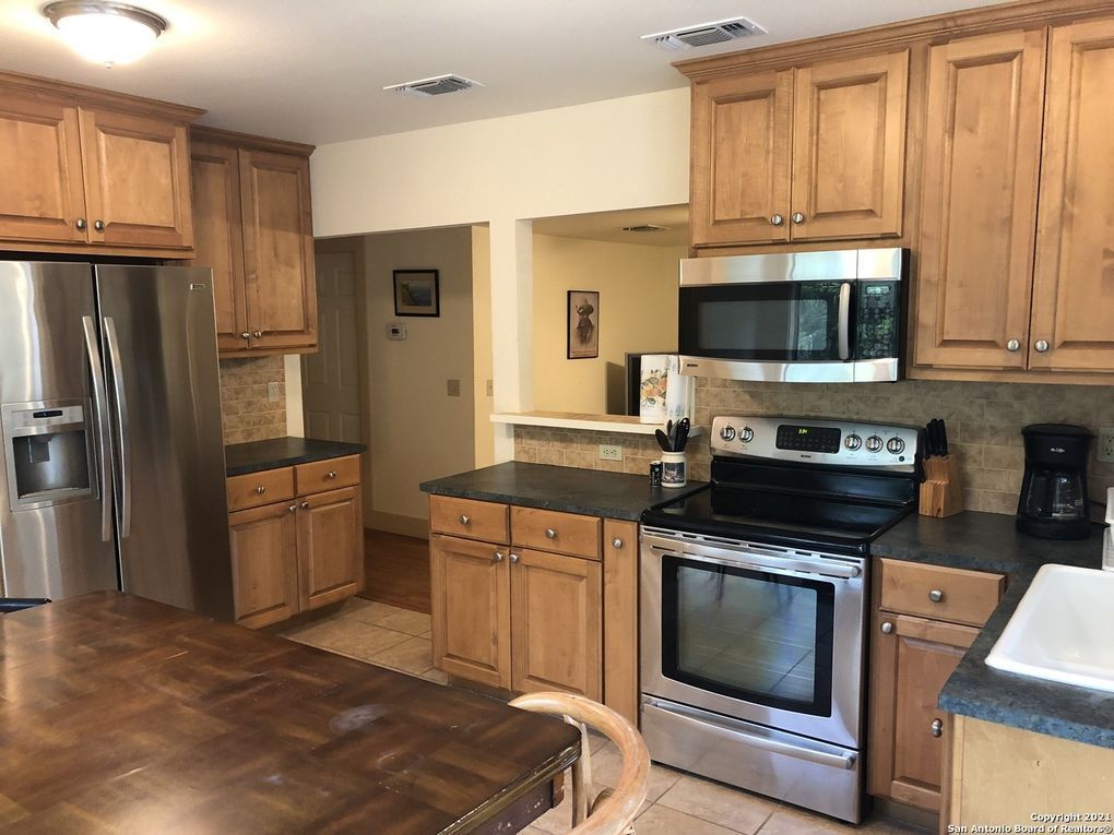 A kitchen with stainless steel appliances and wooden cabinets