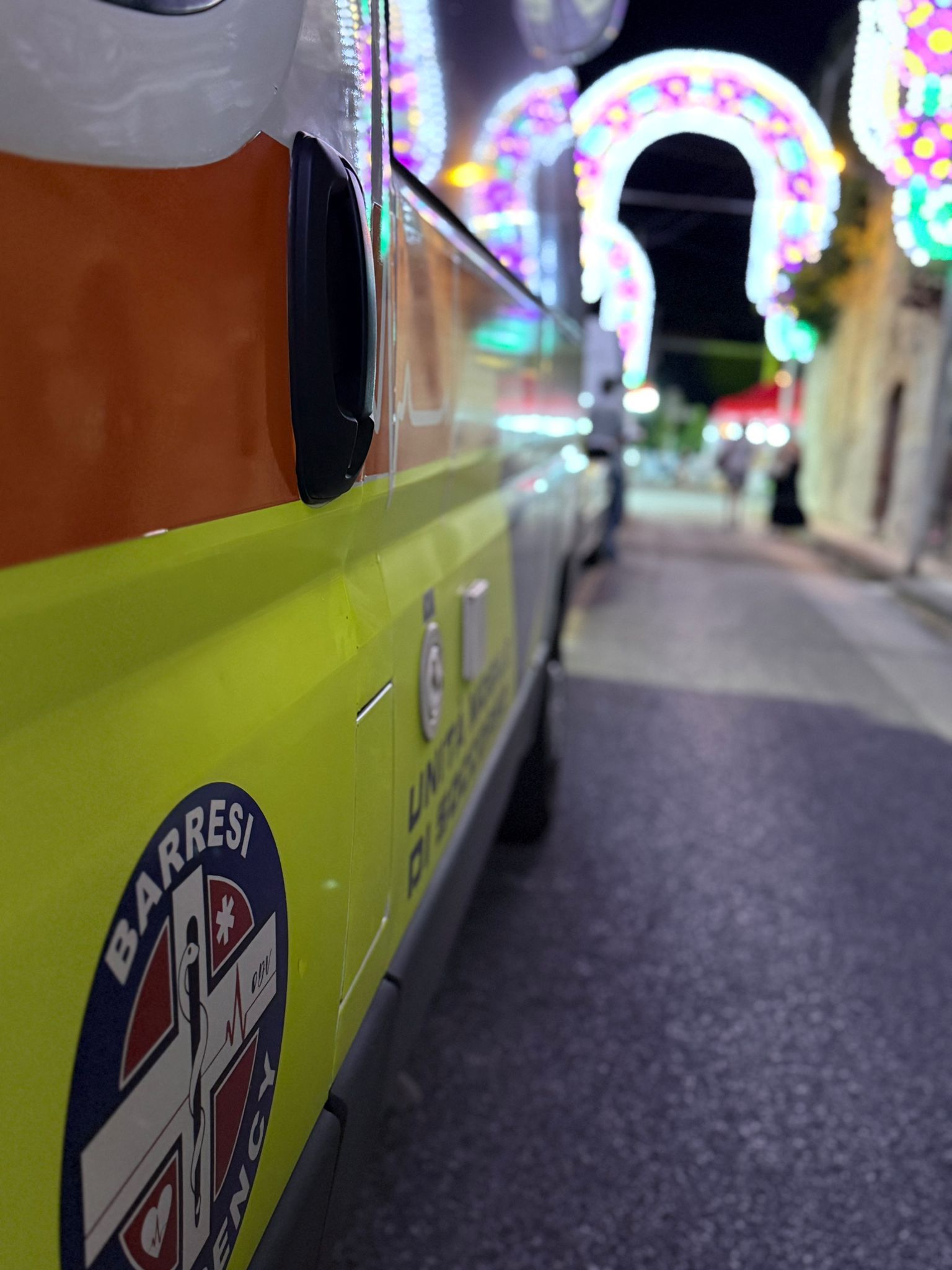 Un'infermiera assiste un anziano con un deambulatore in una casa di cura. L'infermiera sorride