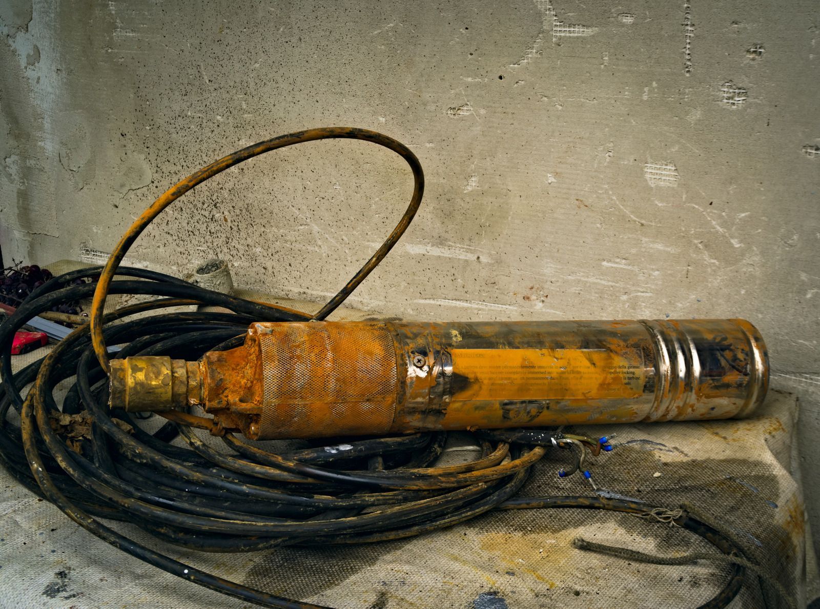 A green tank with three pumps attached to it in a room.