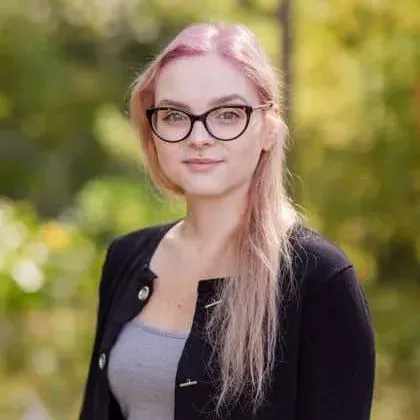 The woman is wearing glasses and a black jacket.