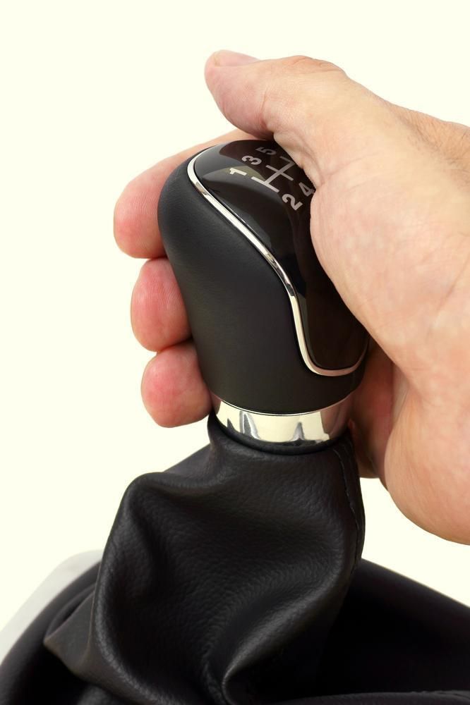Main sur le levier de vitesse noir de la voiture, prêt à changer de vitesse.