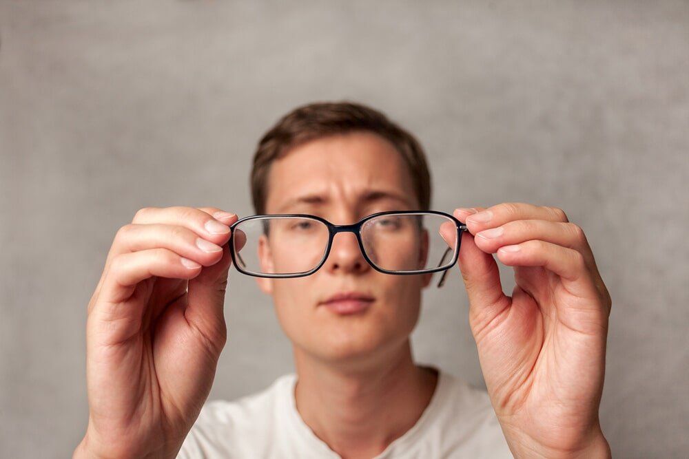 Man Holding Glasses - Clear Optometry In Bargara, QLD