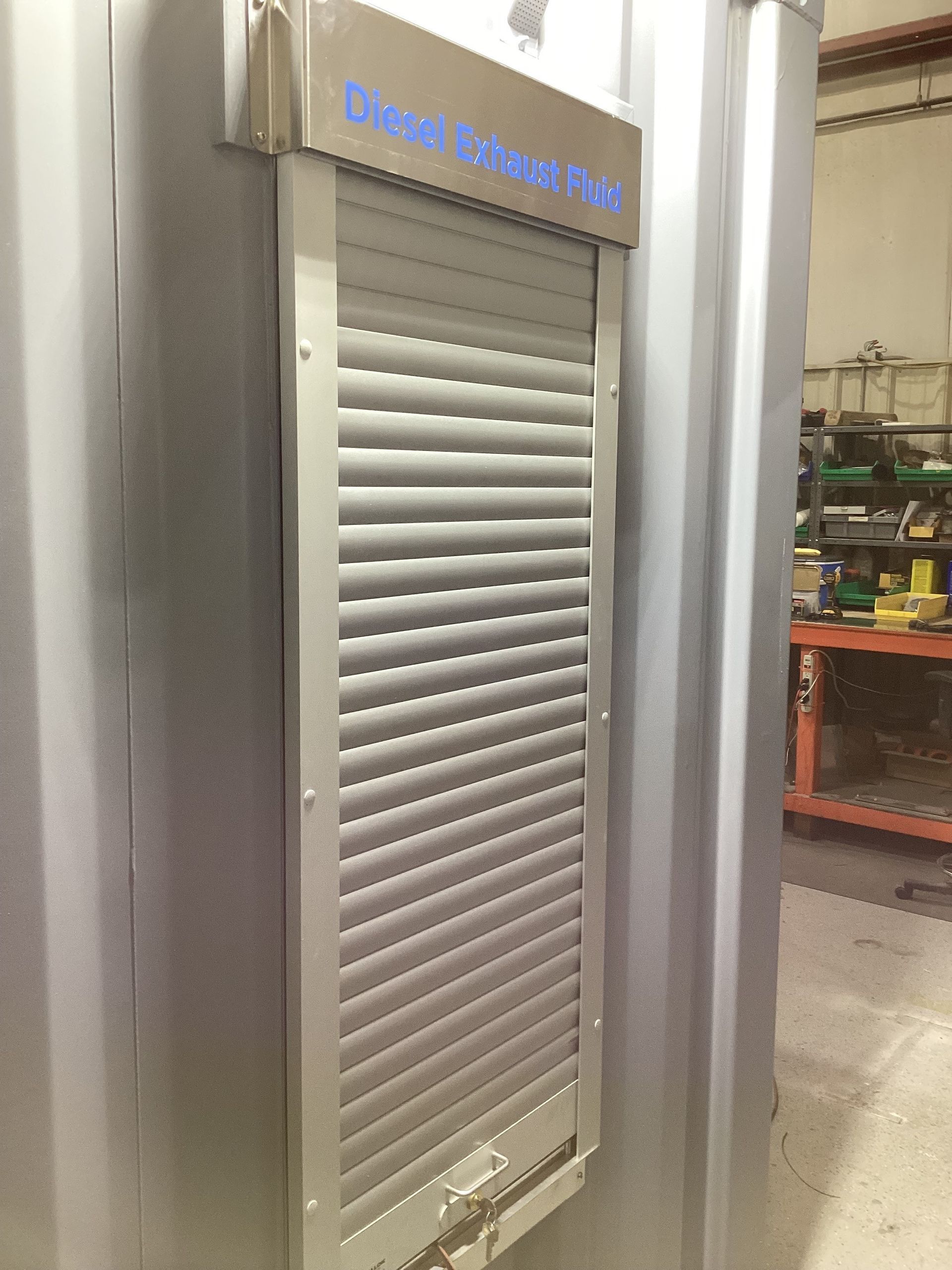 Gray metal shutter on a gray metal container, possibly industrial, with the text 