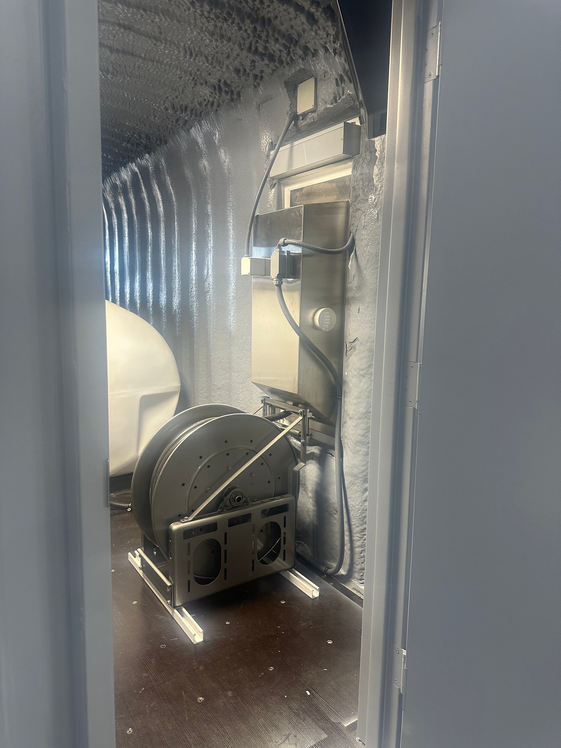 Inside a car wash: equipment, soap, and water visible.