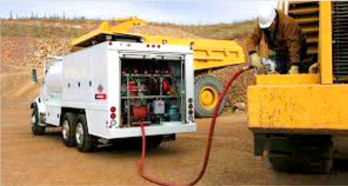 Fuel truck refueling heavy equipment at a construction site.