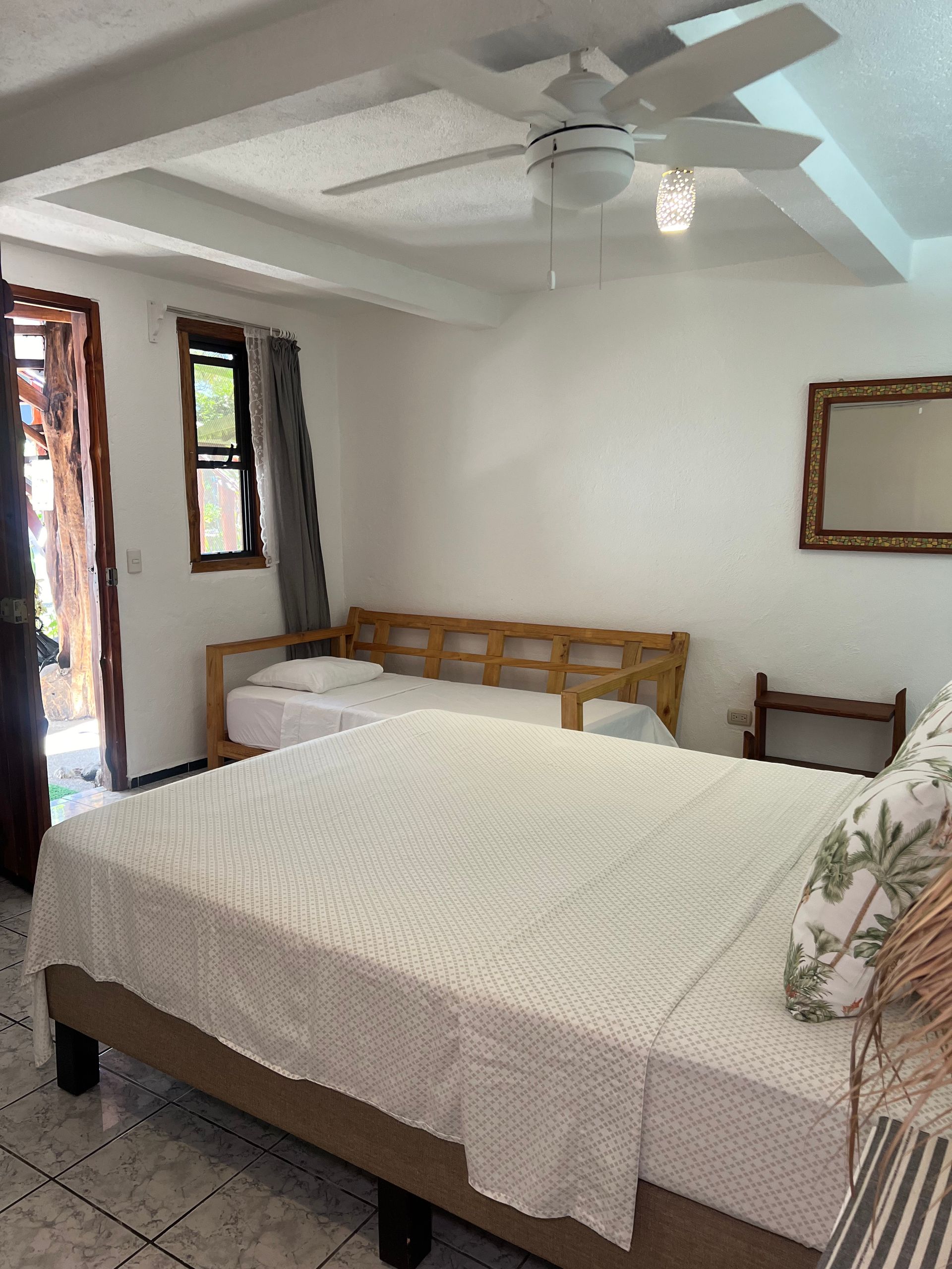 A bedroom with two beds and a ceiling fan