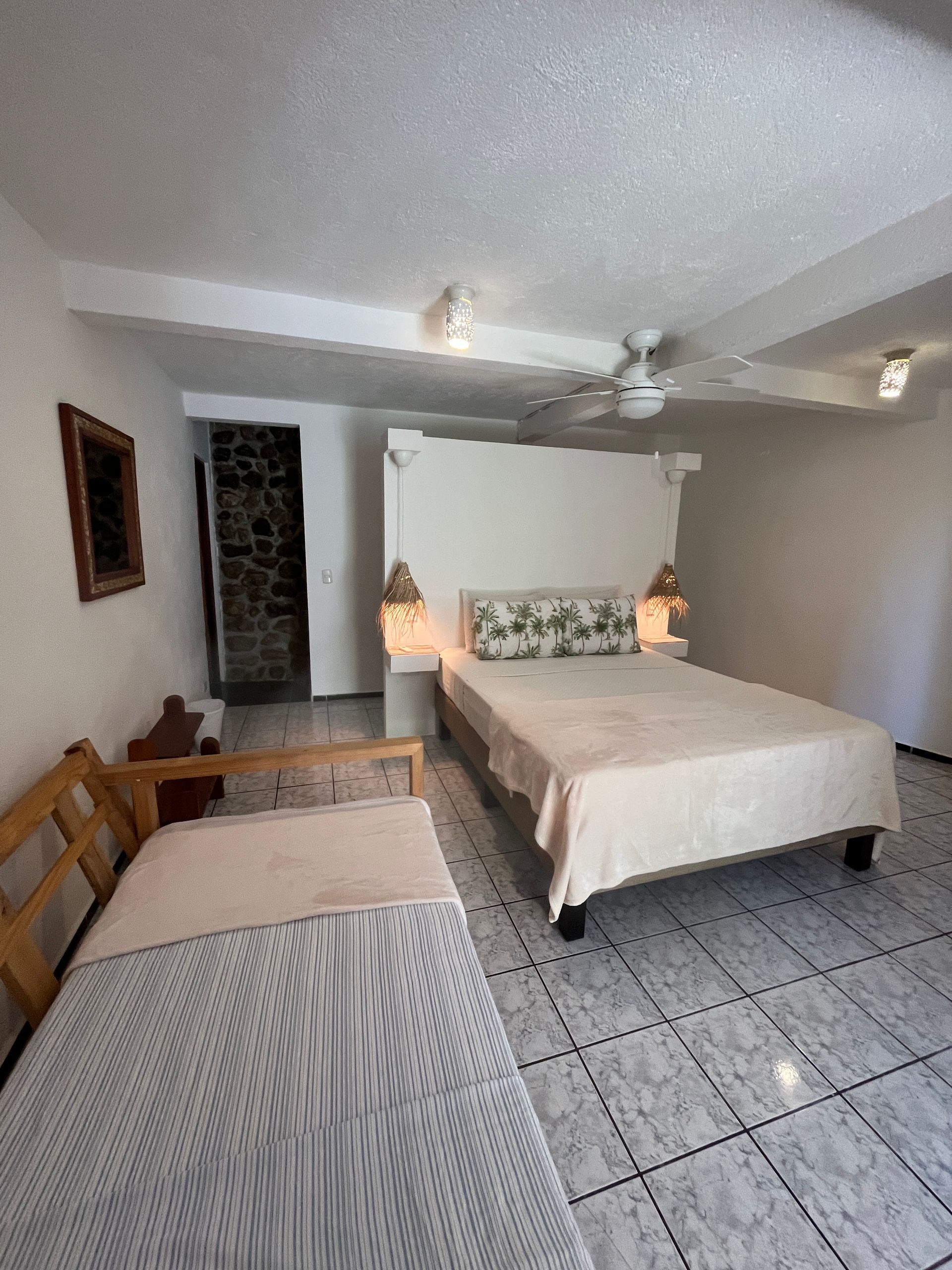 A bedroom with two beds and a ceiling fan.