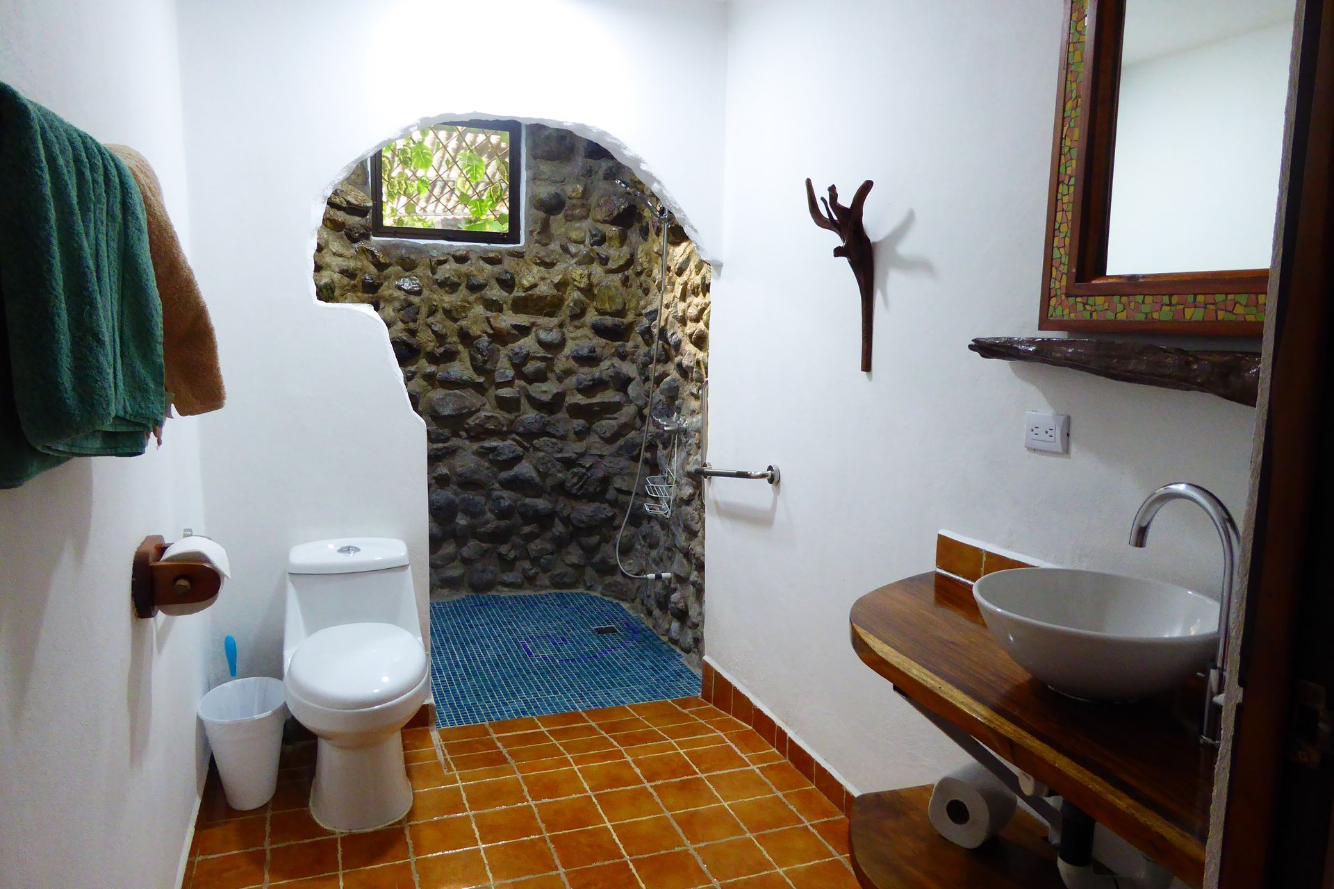 A bathroom with a toilet a sink and a mirror