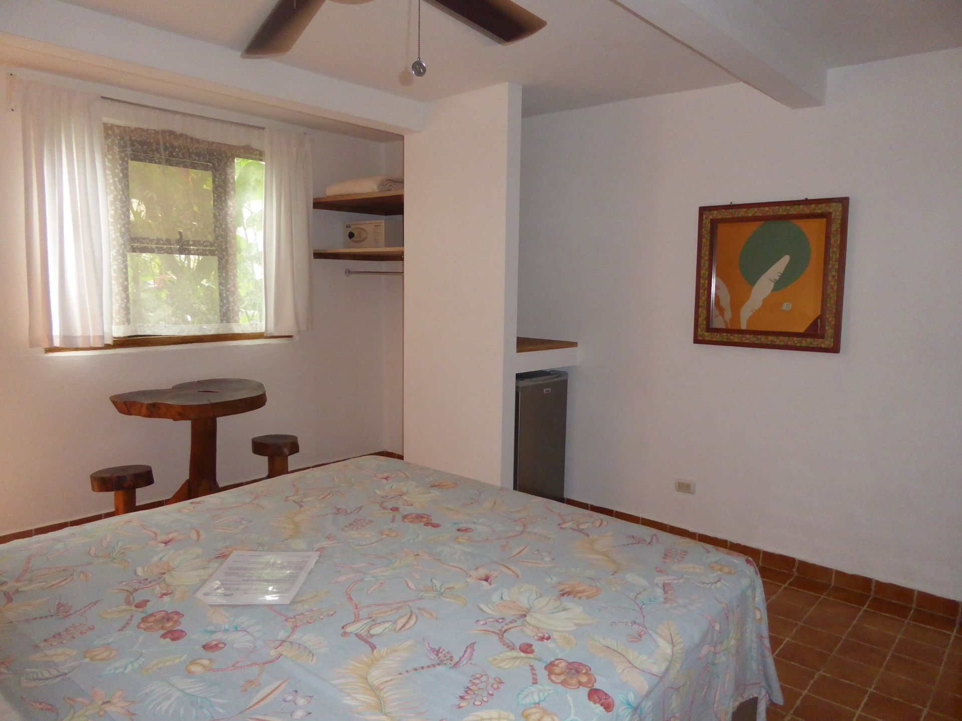 A bedroom with a large bed and a ceiling fan