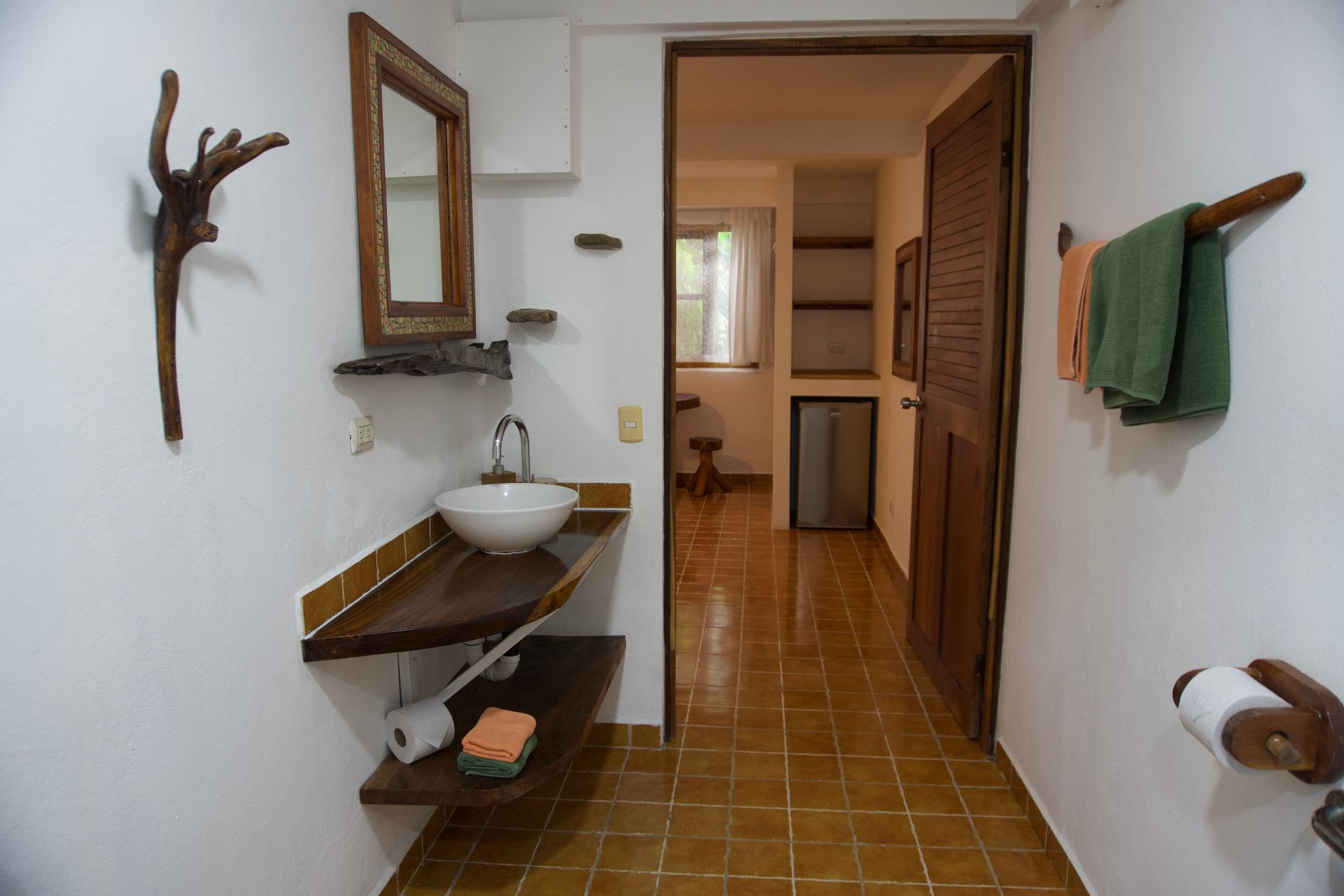 A bathroom with a sink , mirror and towel rack.
