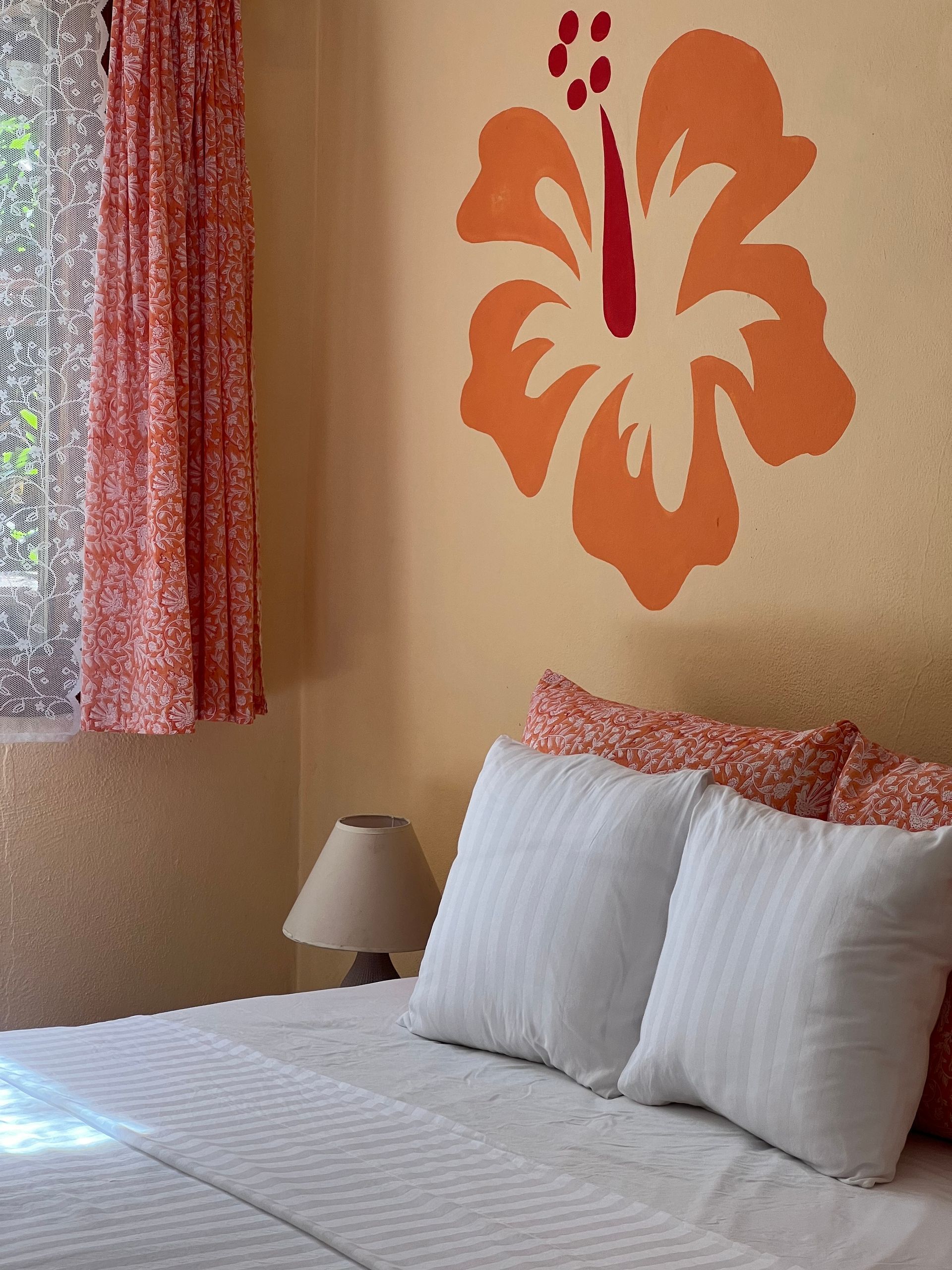 A bedroom with a large flower on the wall above the bed