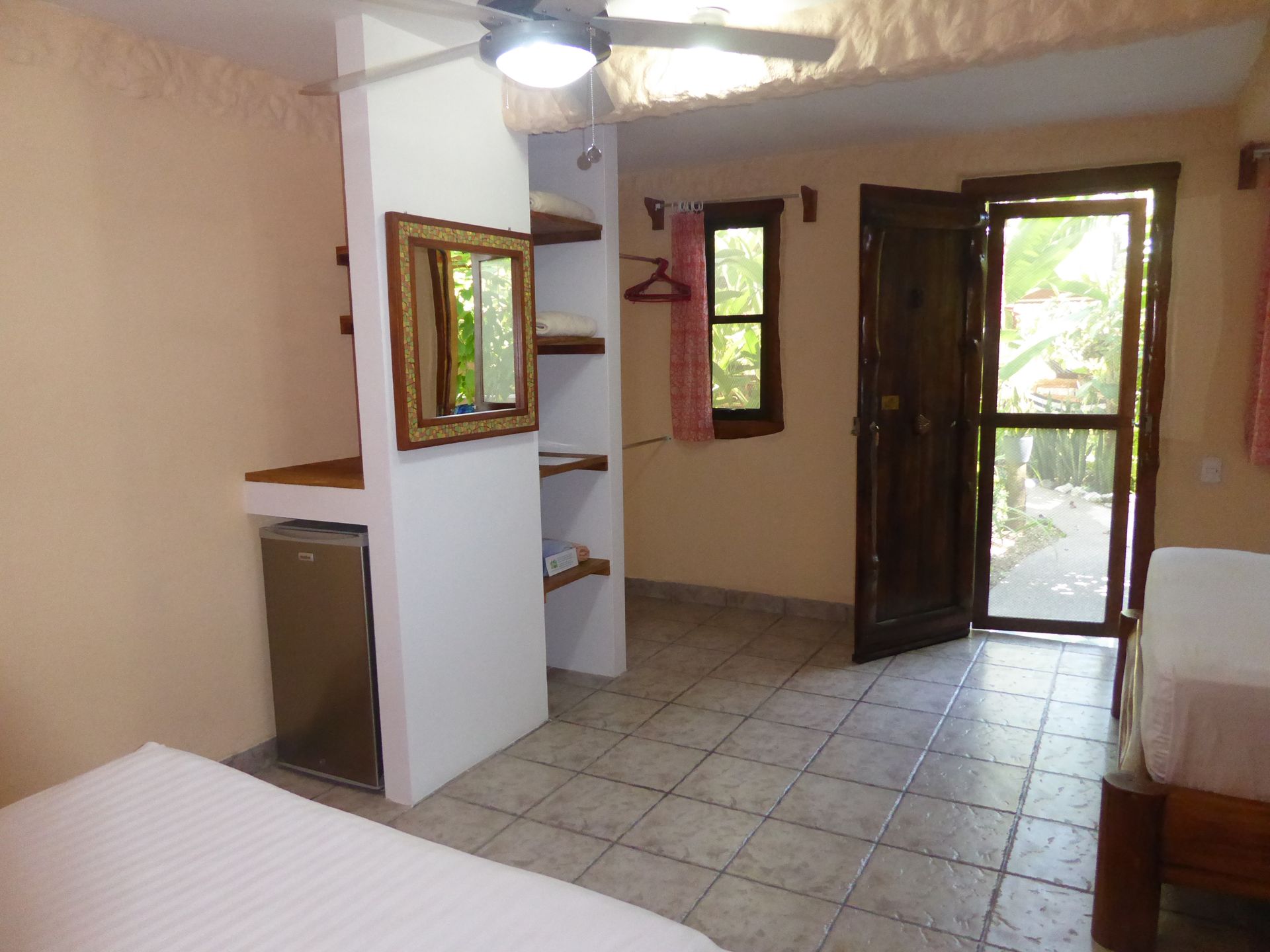 A bedroom with two beds and a ceiling fan