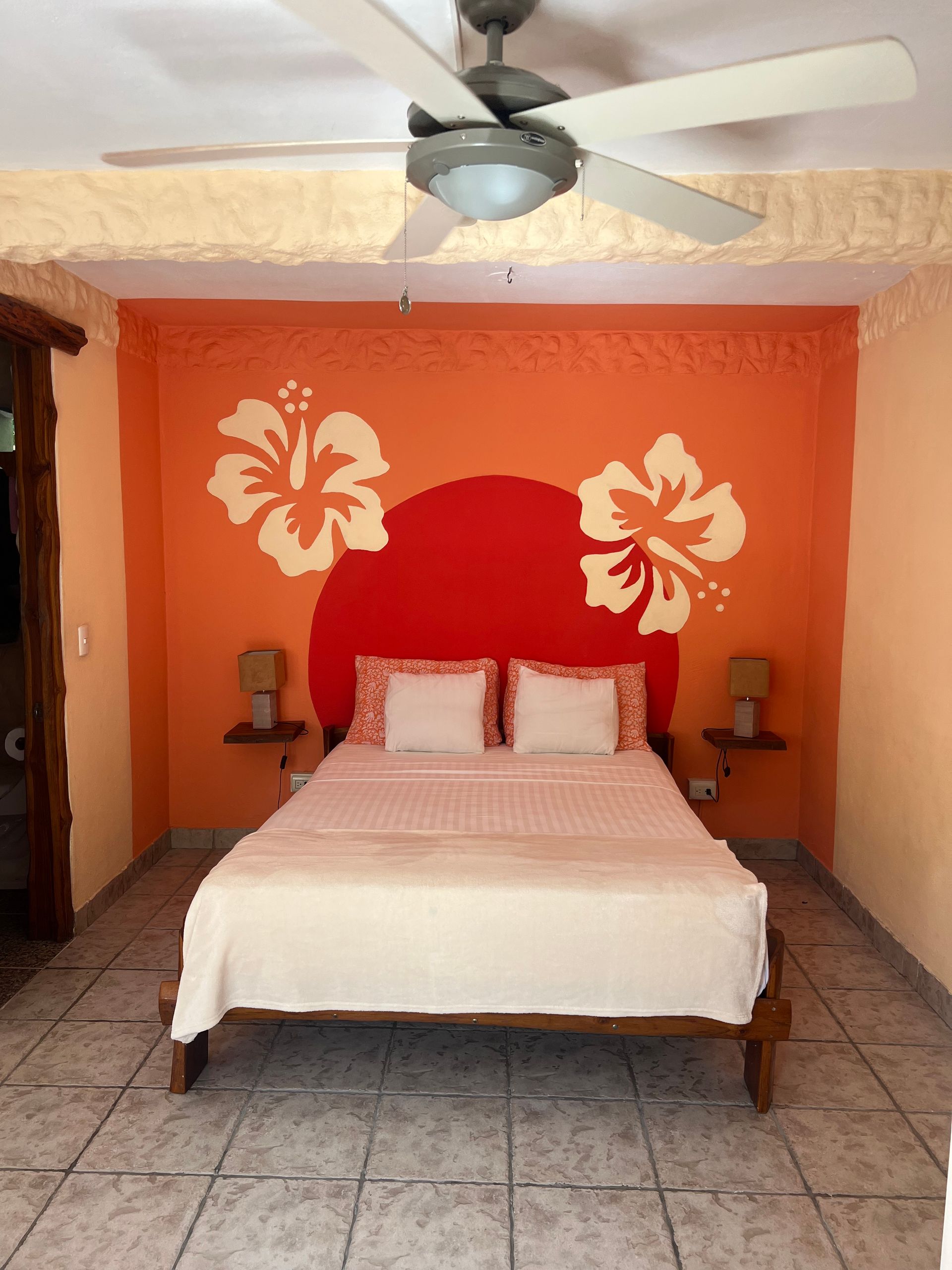 A bedroom with a bed and a ceiling fan