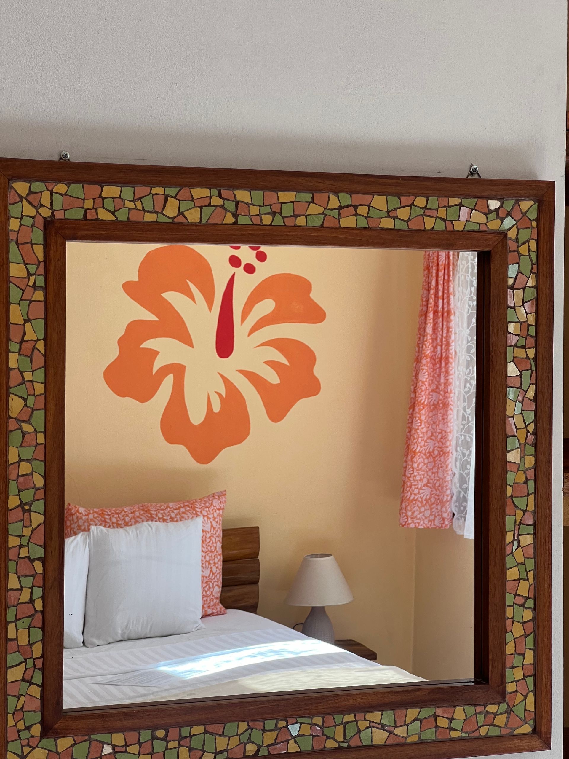 A bedroom with a hibiscus flower painted on the wall