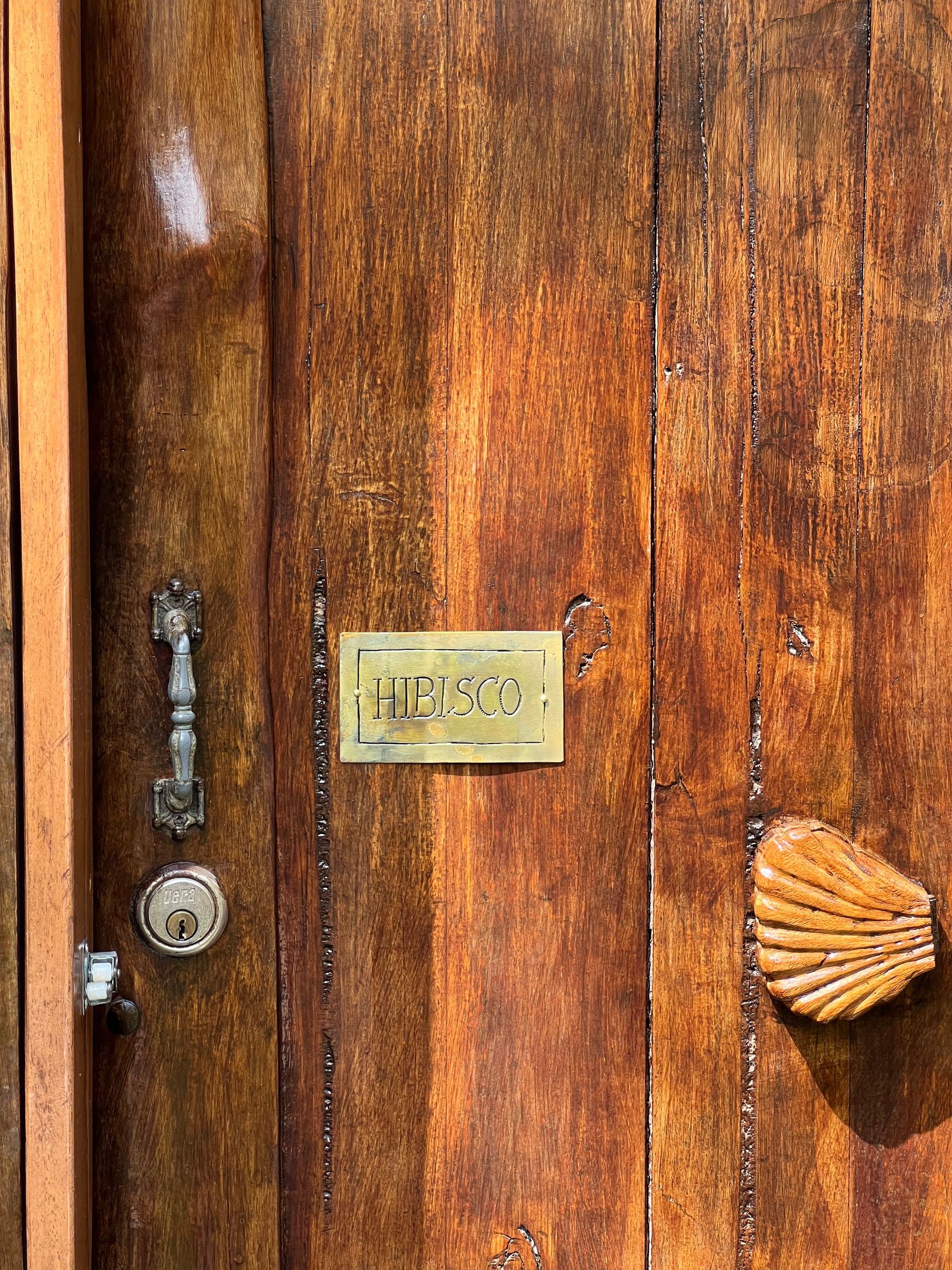 A close up of a wooden door with a brass sign on it.