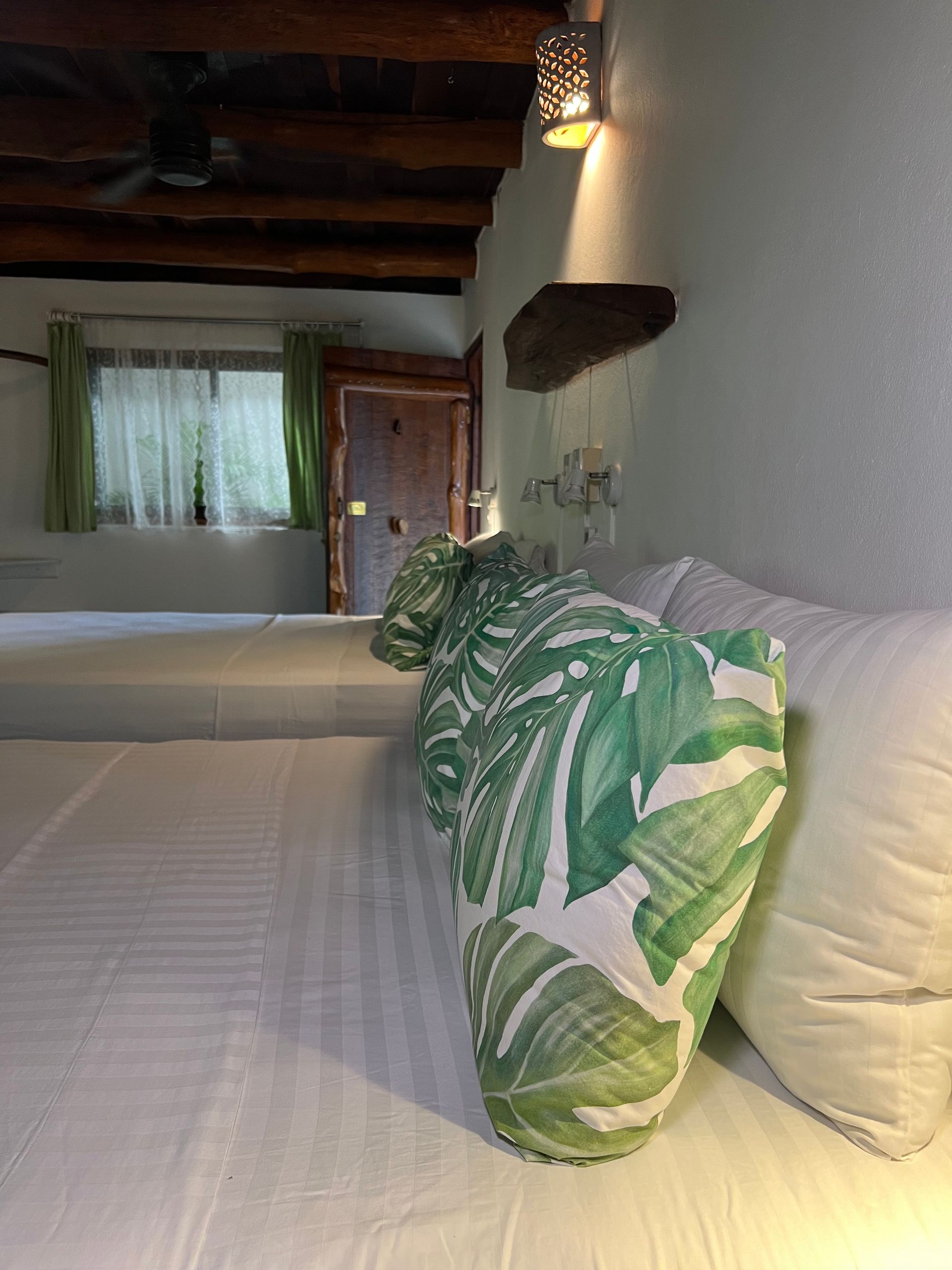 A bedroom with two beds and a green pillow on the bed.