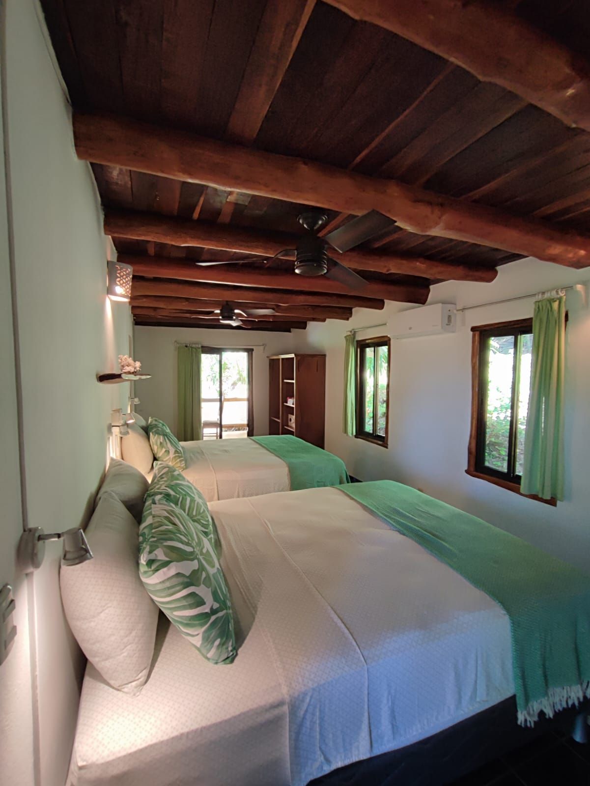 A bedroom with two beds and a ceiling fan.