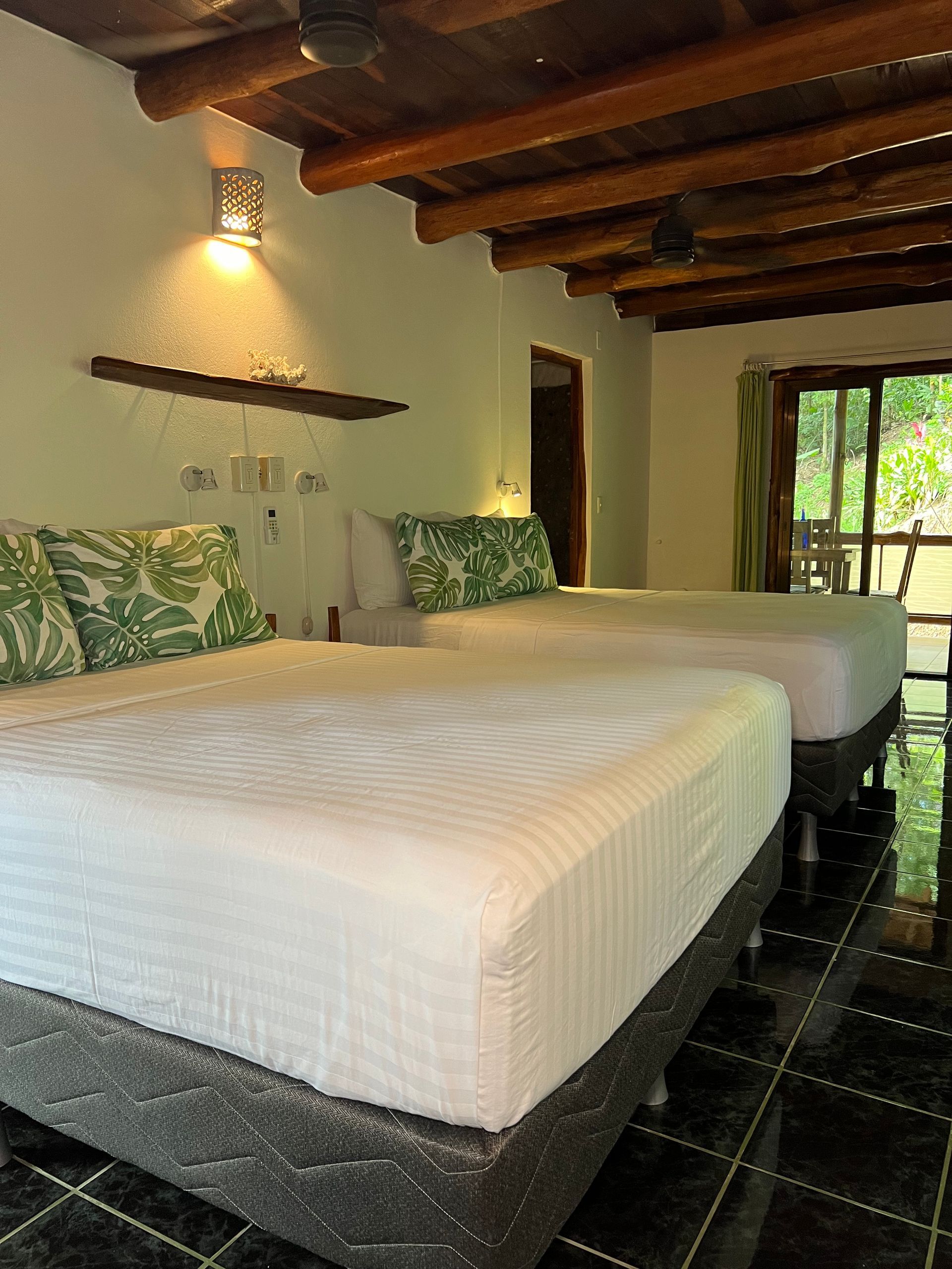 A hotel room with two beds and a ceiling fan.