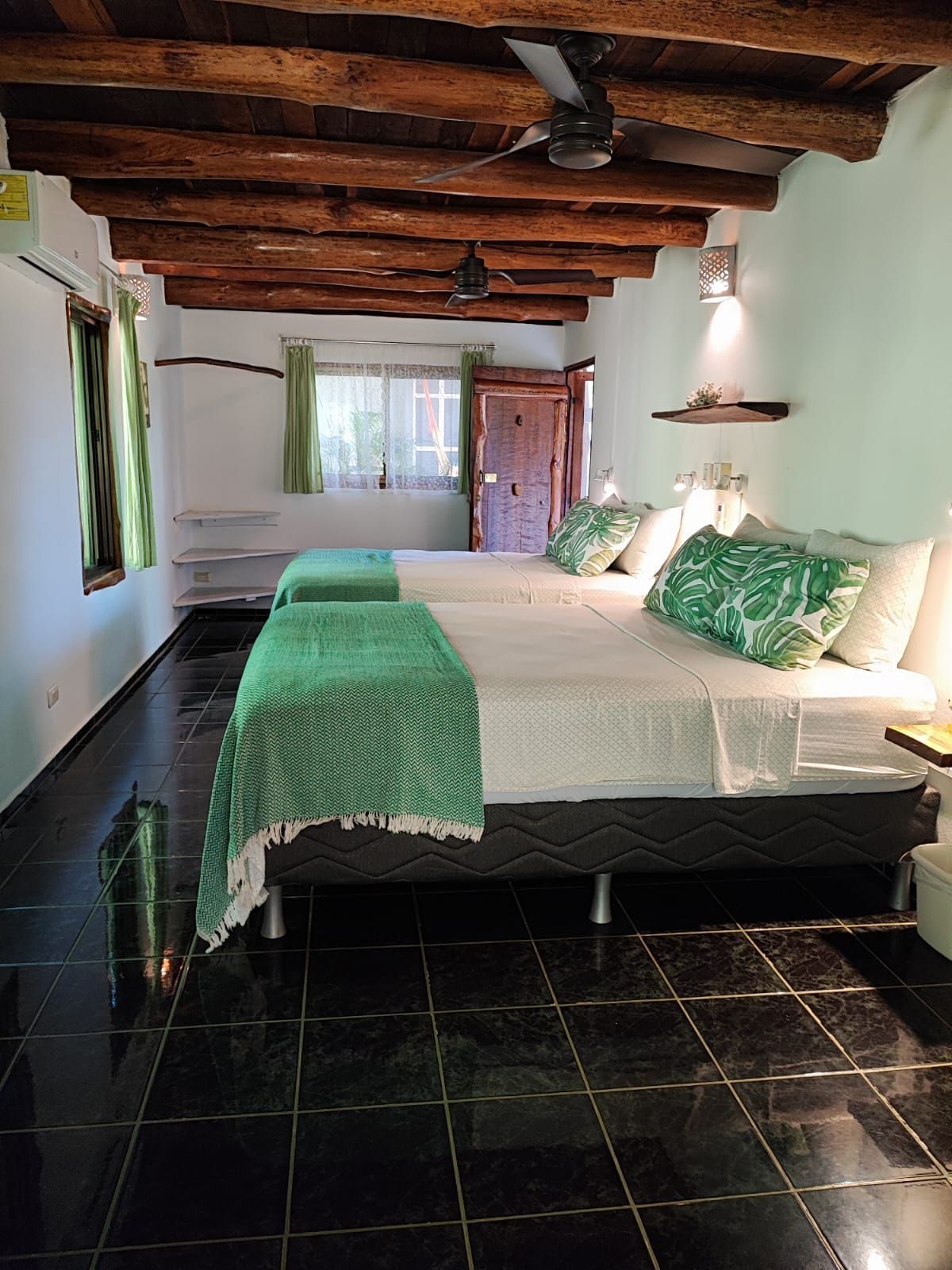 A hotel room with two beds and a ceiling fan.