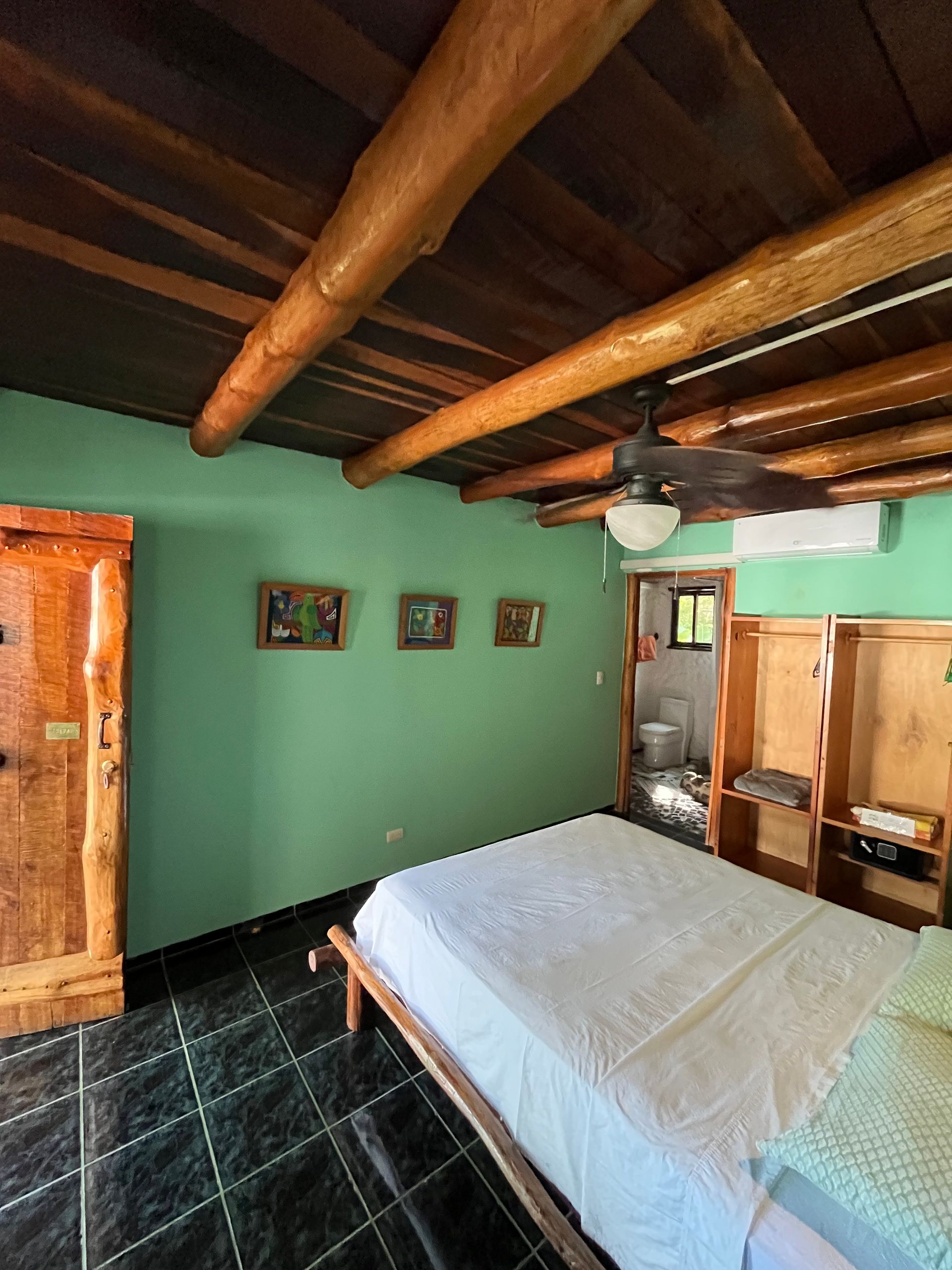 A bedroom with a bed and a ceiling fan.