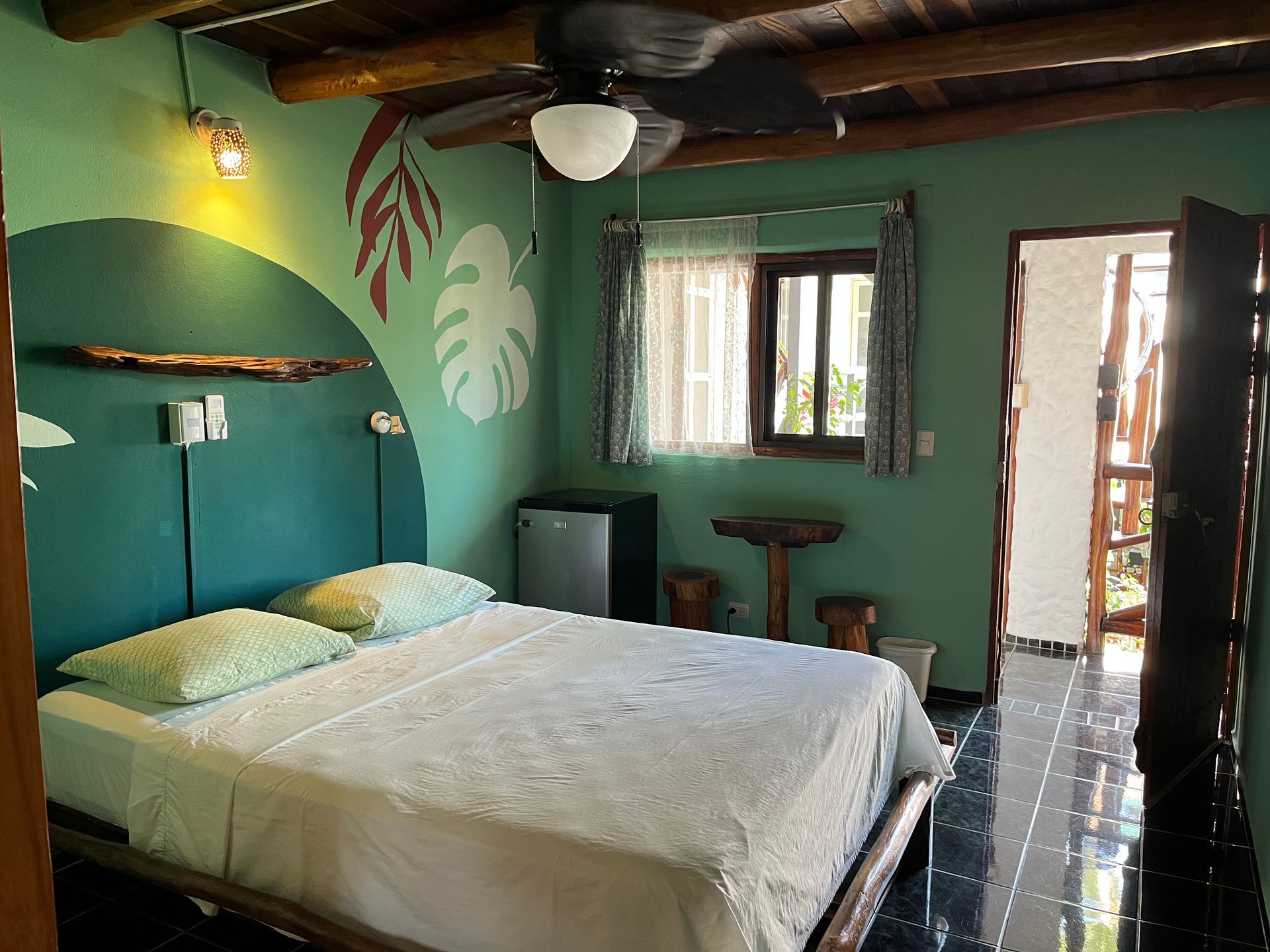 A bedroom with a king size bed and a ceiling fan.