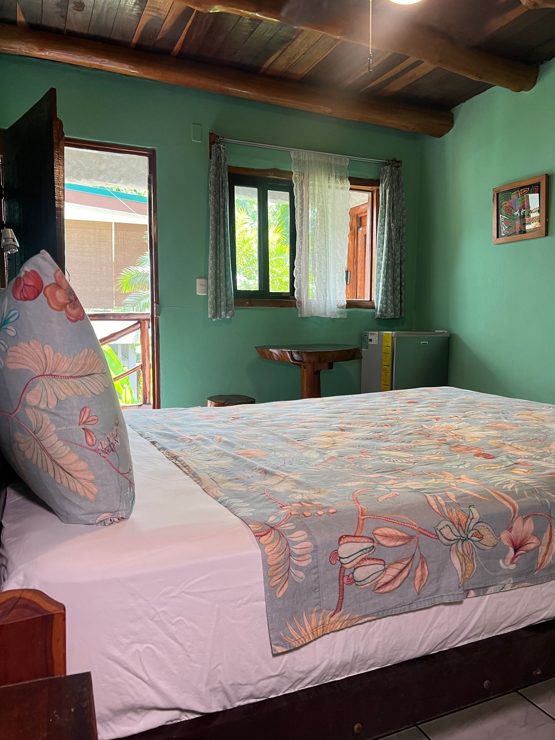 A bedroom with a bed , table , and window.