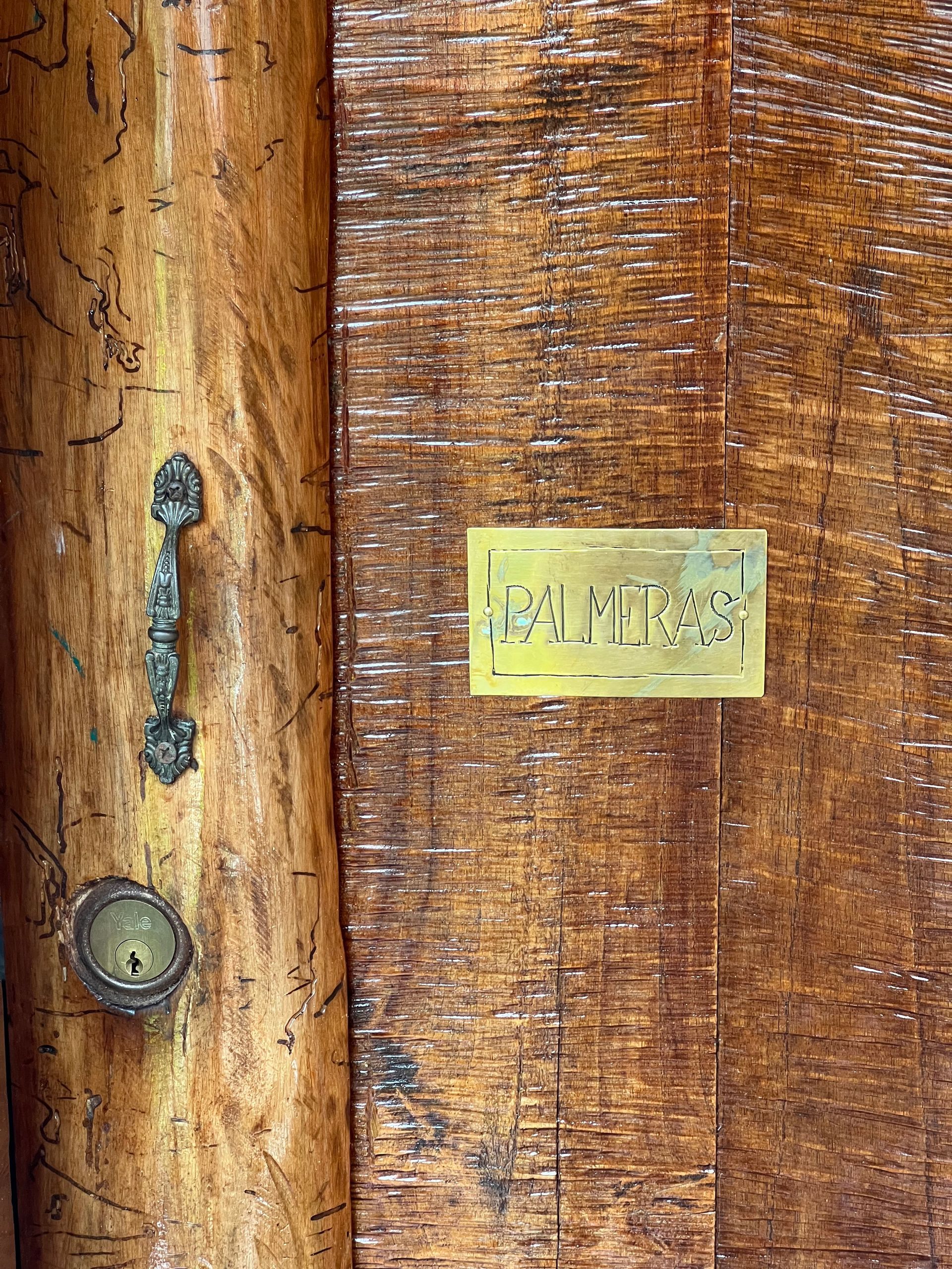 A close up of a wooden door with a handle and a sign on it.