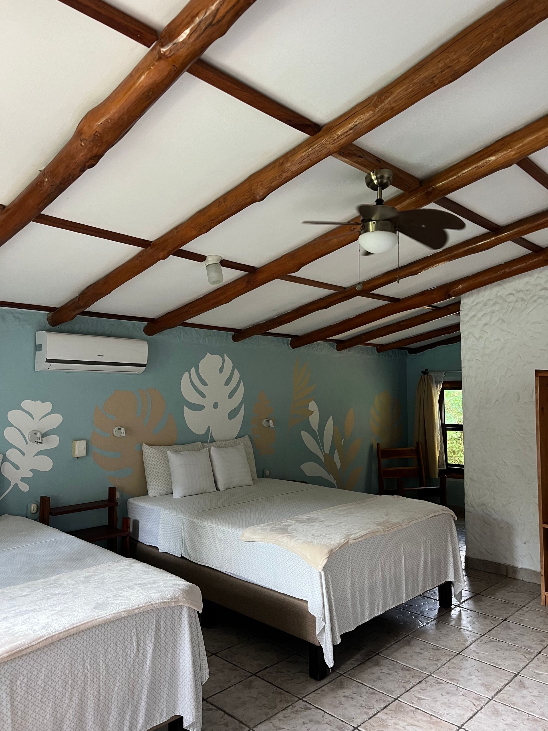 A bedroom with two beds and a ceiling fan