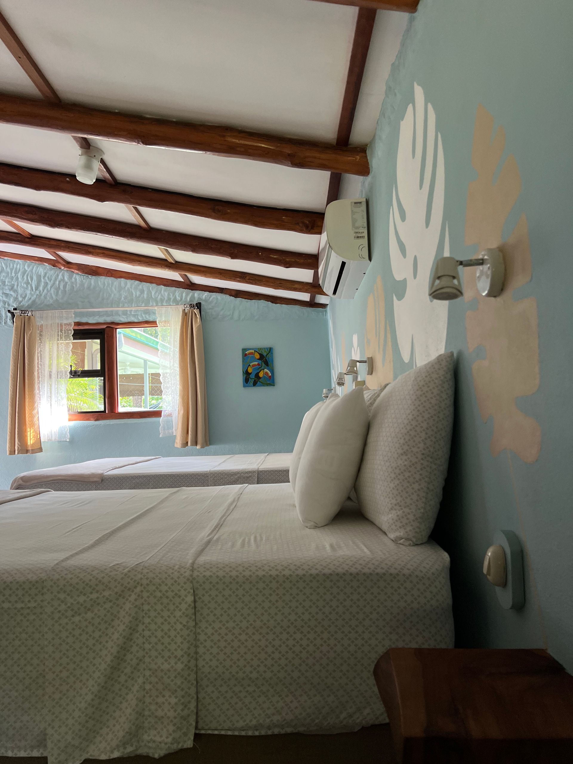 A hotel room with two beds and a window