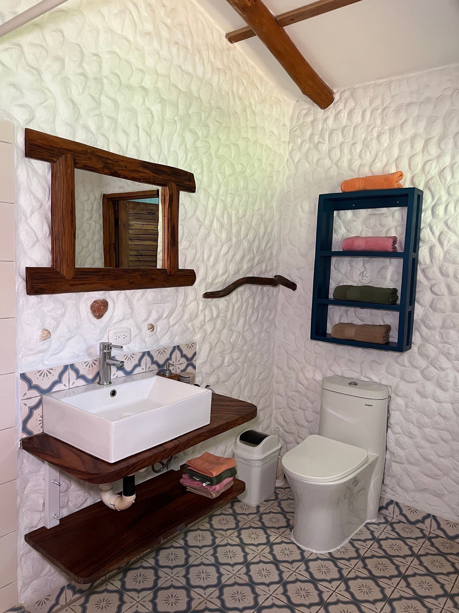 A bathroom with a sink , toilet and mirror.
