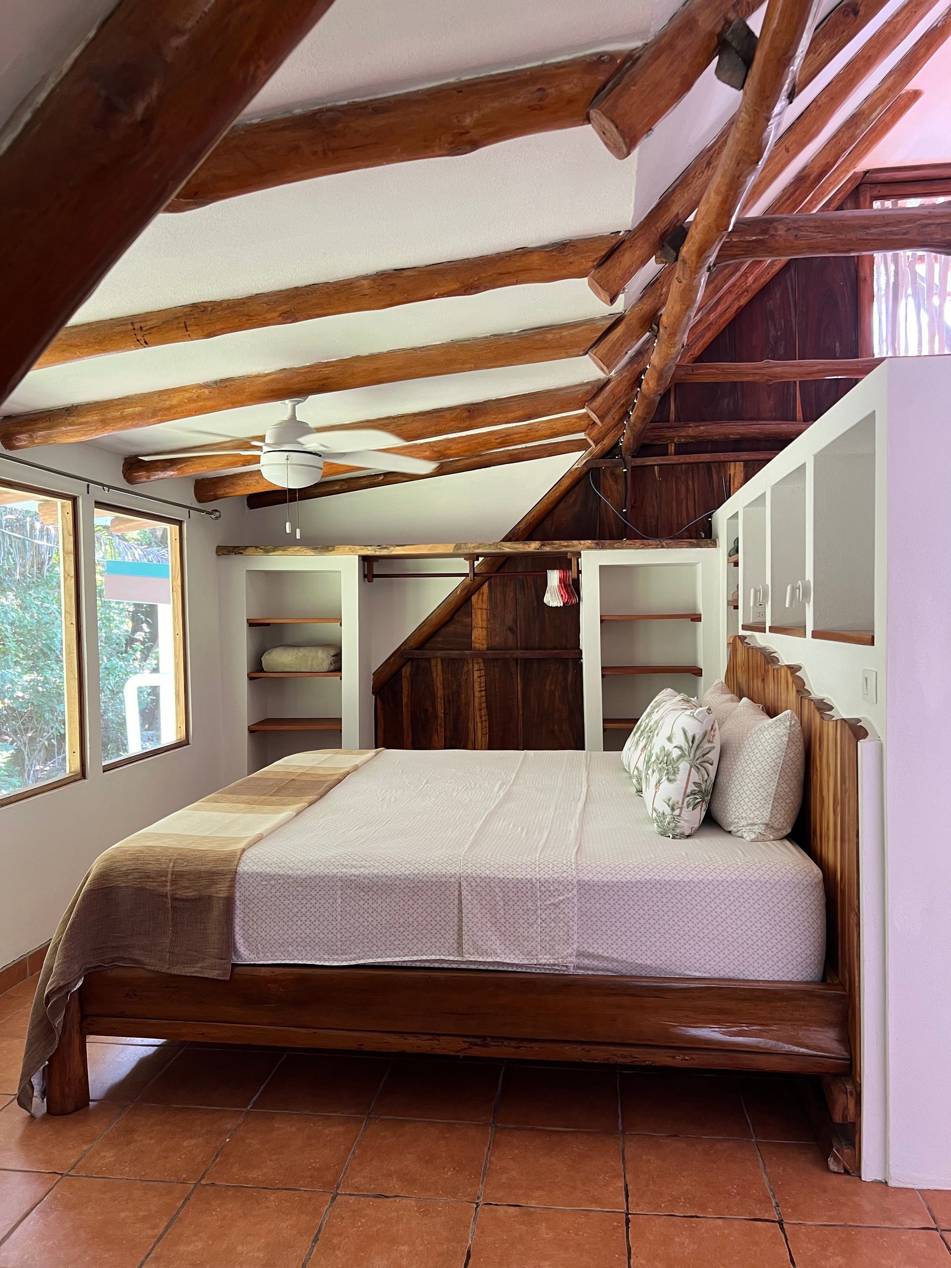 A bedroom with a king size bed and a ceiling fan