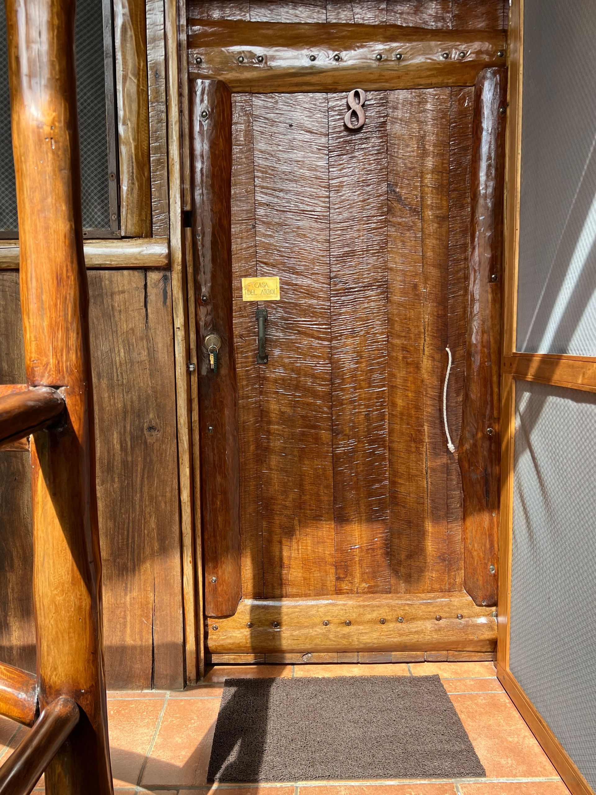 A wooden door with a black mat in front of it.