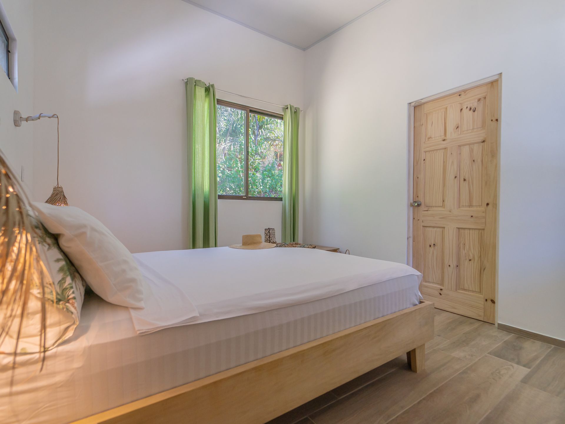 A bedroom with a bed , window and door.