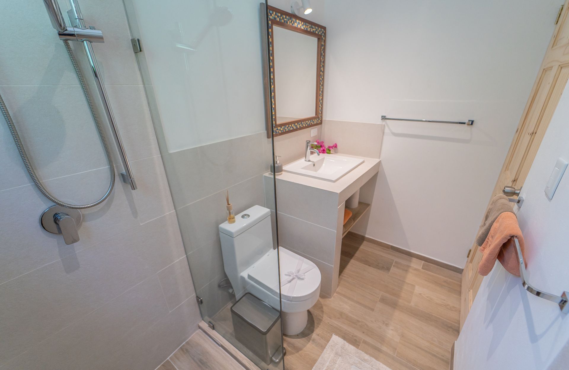 A bathroom with a toilet , sink and shower.