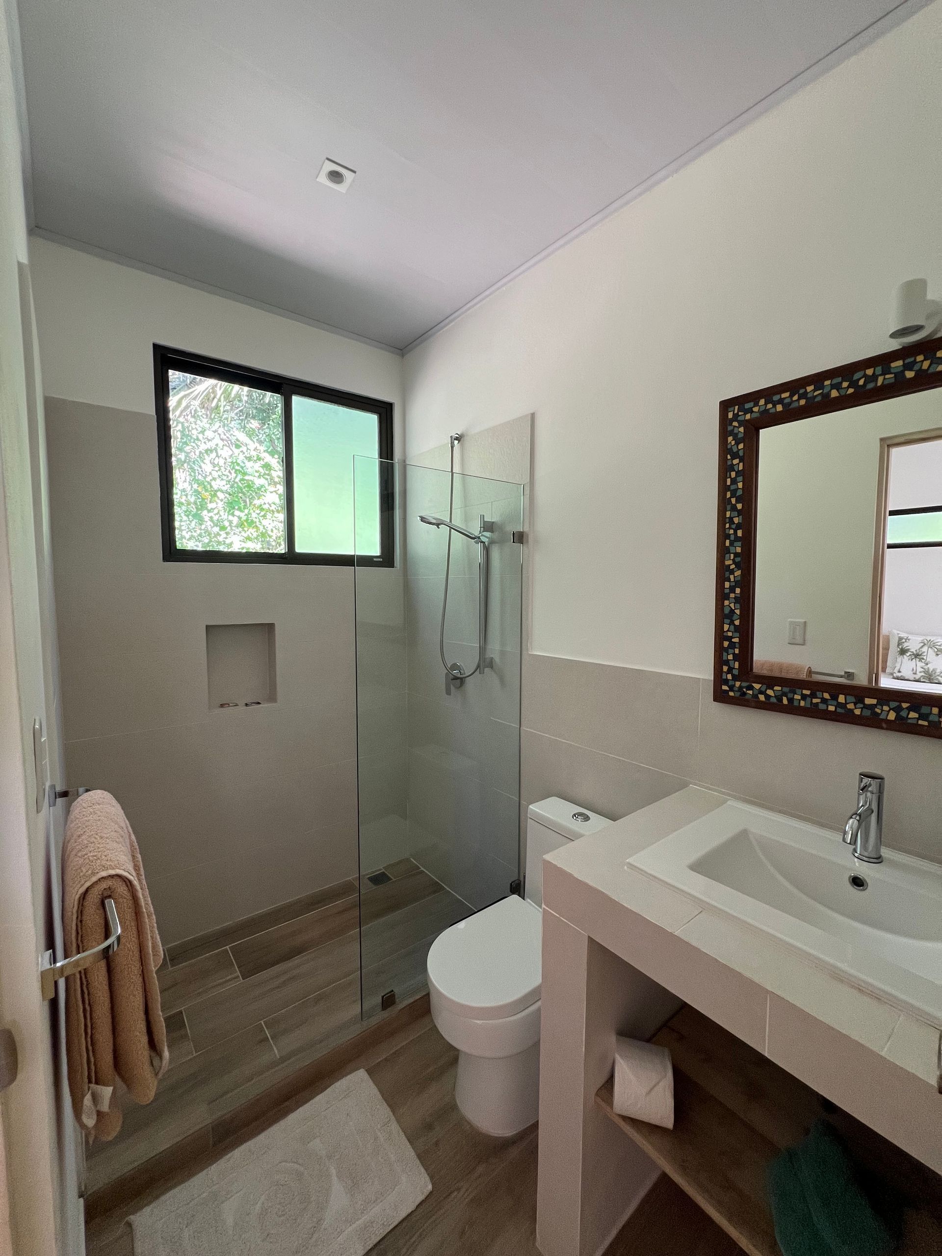 A bathroom with a toilet a sink and a mirror