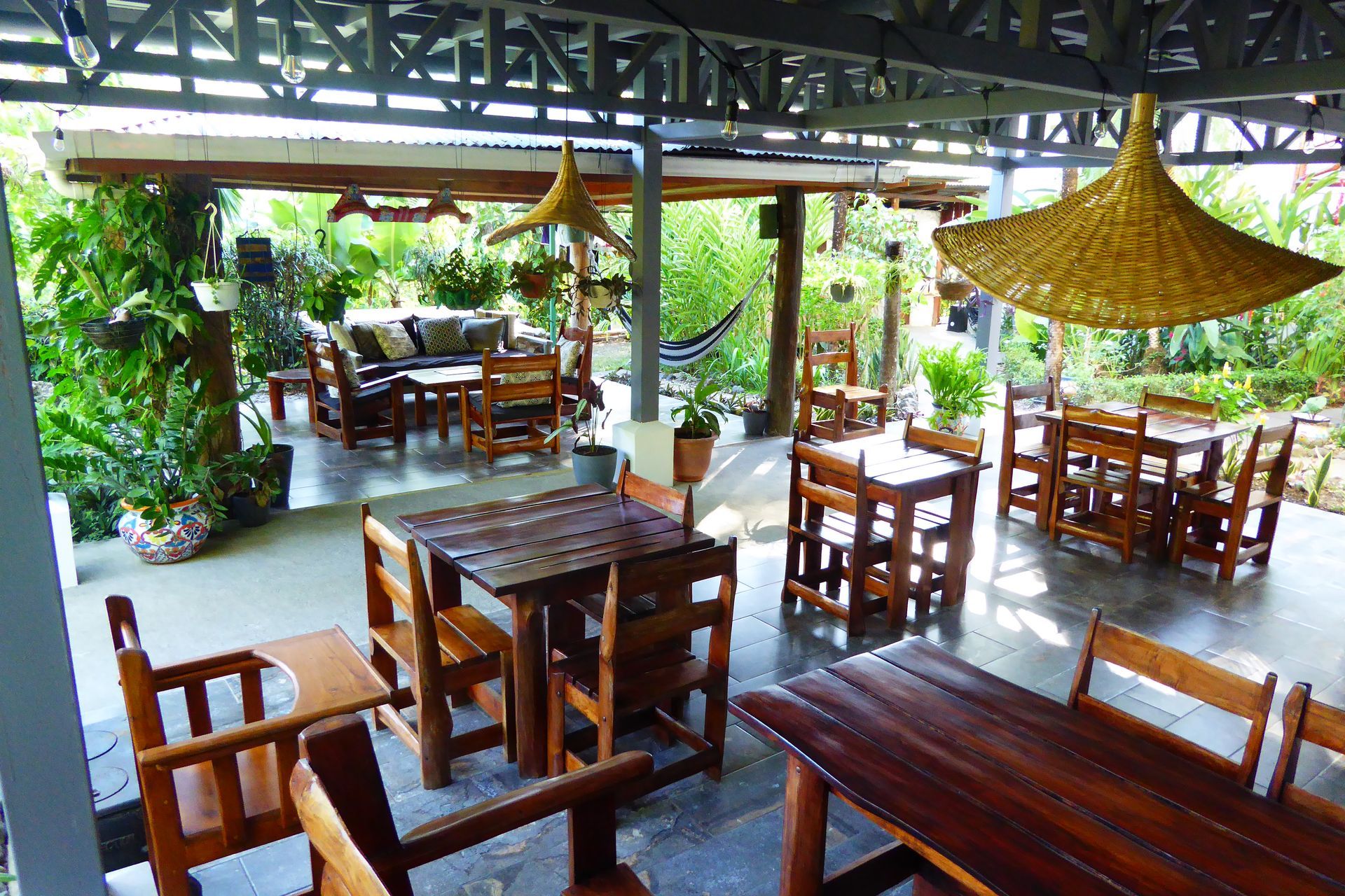 A patio with tables and chairs under a canopy