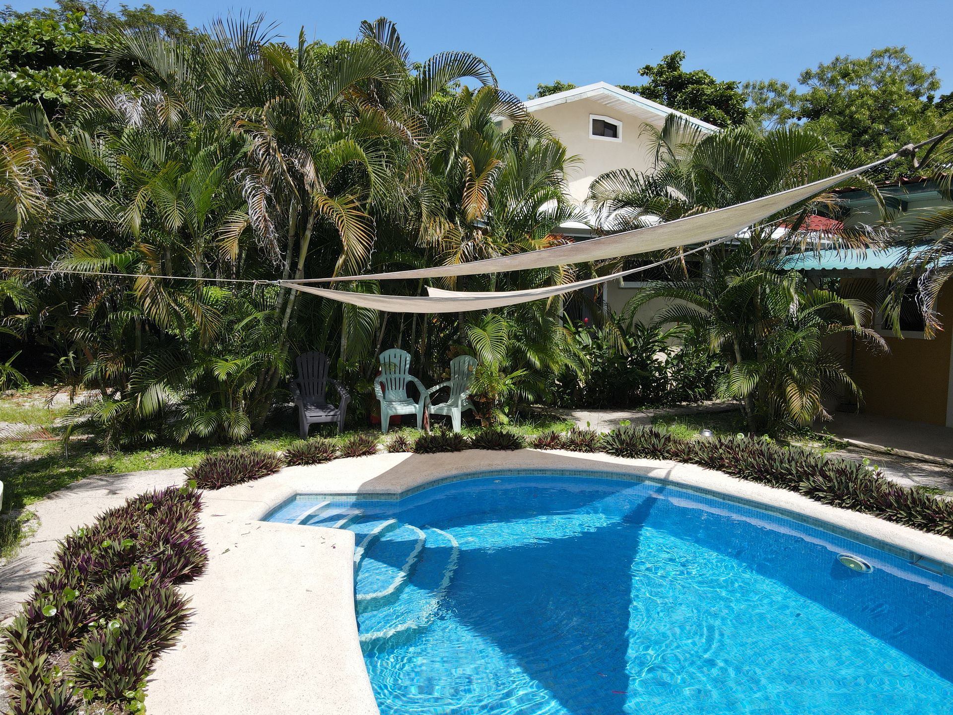 A large swimming pool with a house in the background