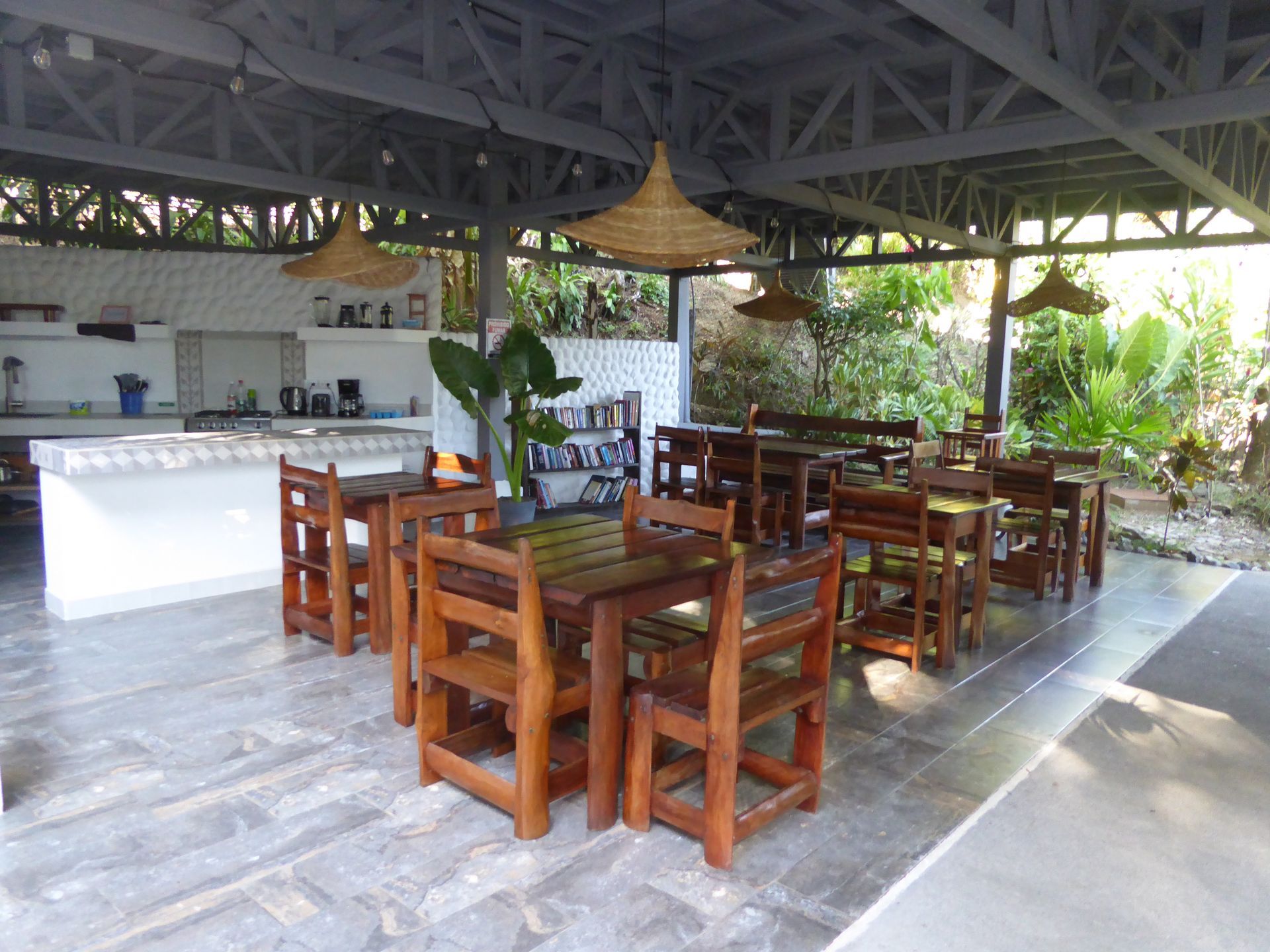A dining area with tables and chairs under a canopy