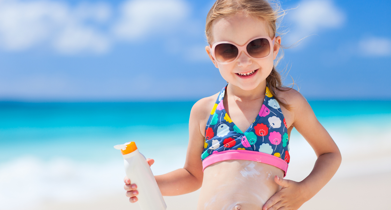 young girl applying sunscreen
