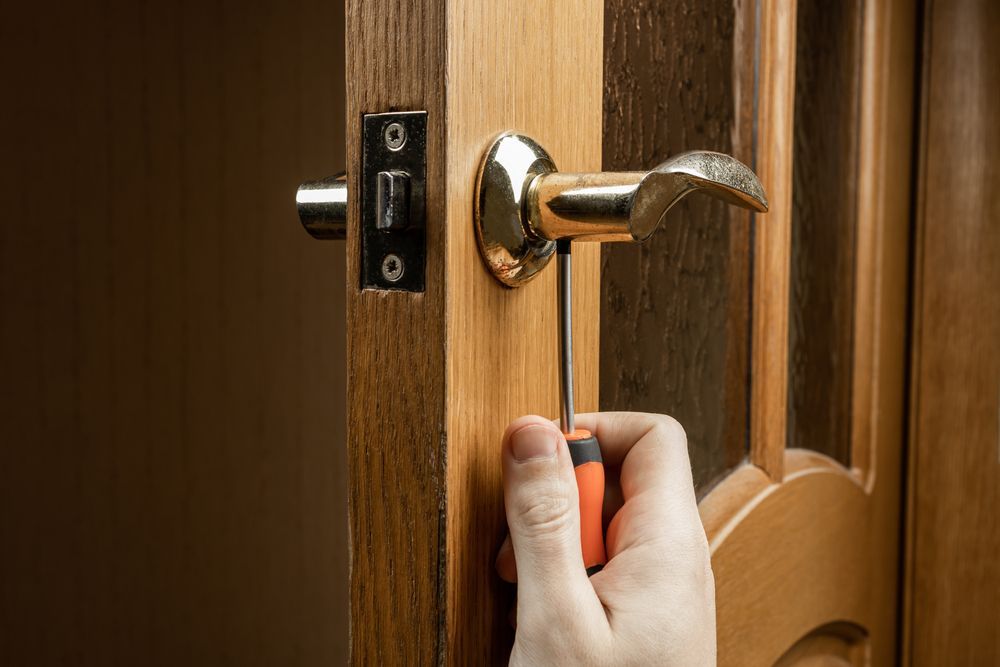A Black Door Handle Is Sitting on A Wooden Door — Fortress Locksmiths & Security in Lennox Head, NSW